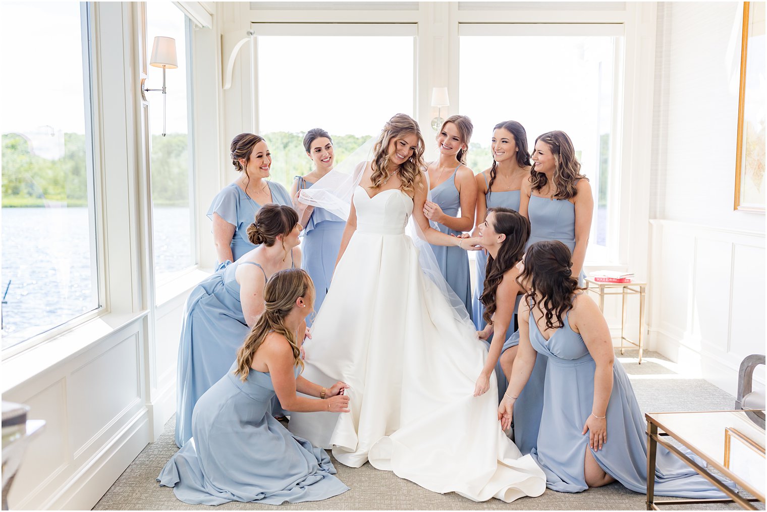bridesmaids adjust bride's gown at The Mill Lakeside Manor