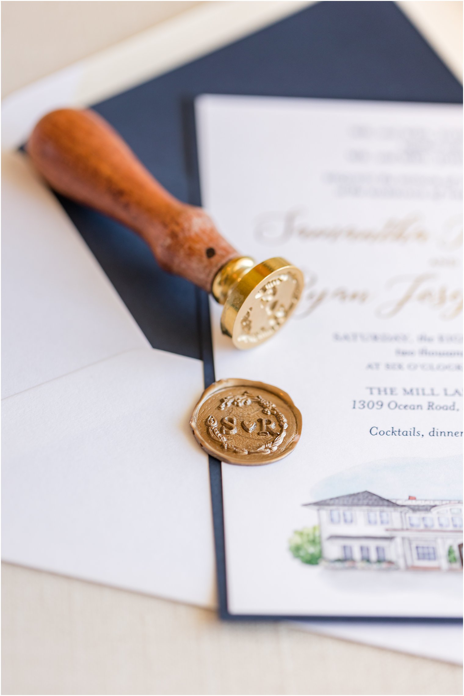gold wax seal on navy and white invitation suite