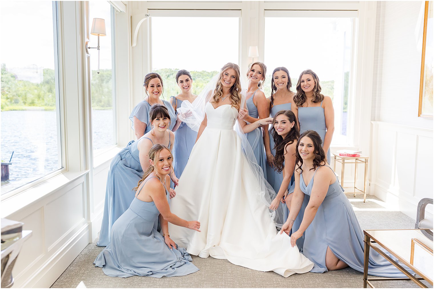 bride and bridesmaids stand in corner helping bride prepare for The Mill Lakeside Manor wedding