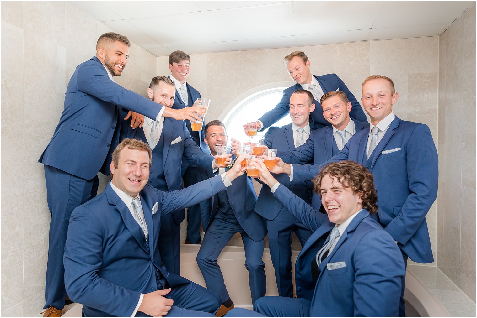 groom toasts with groomsmen in navy suits at The Mill Lakeside Manor