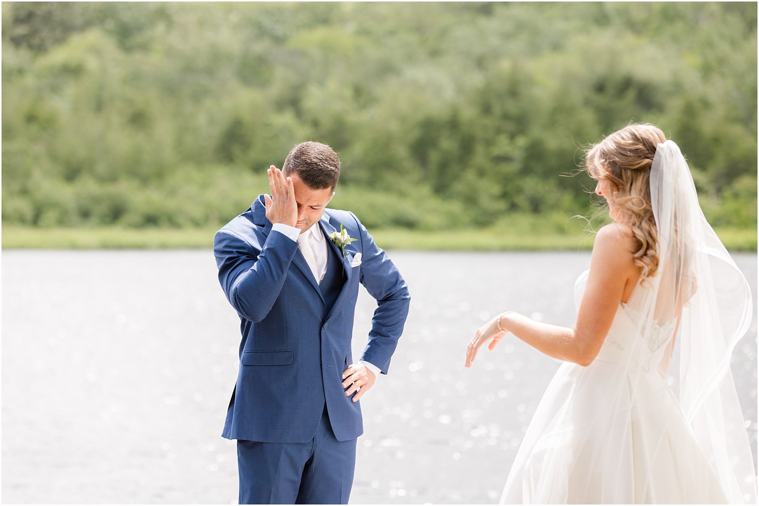 groom stands with hand on hip crying as he sees bride