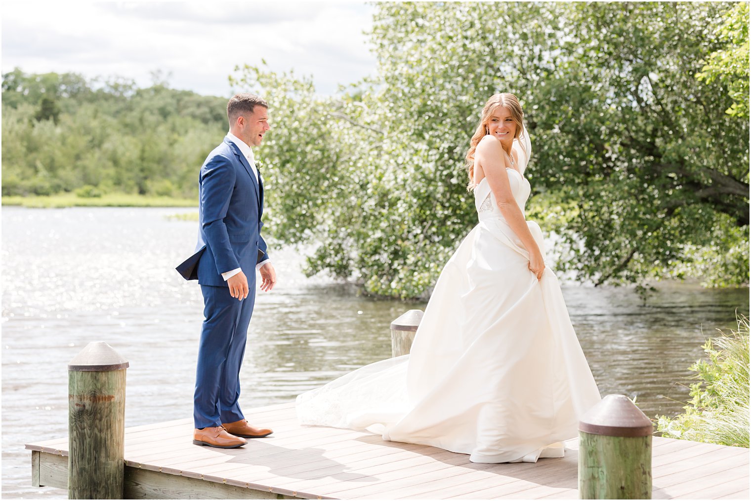 bride shows off wedding gown on dock at The Mill Lakeside Manor