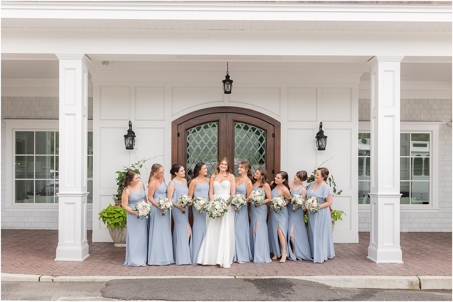 bride poses with bridesmaids in light blue gowns at The Mill Lakeside Manor