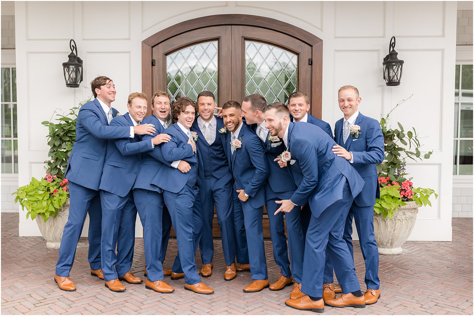 groom laughs with groomsmen in navy suits