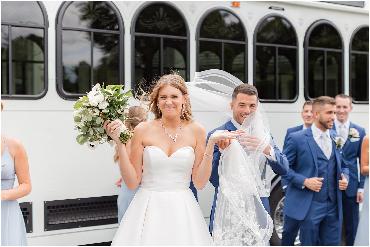 bride shrugs during wedding photos on windy day in New Jersey 