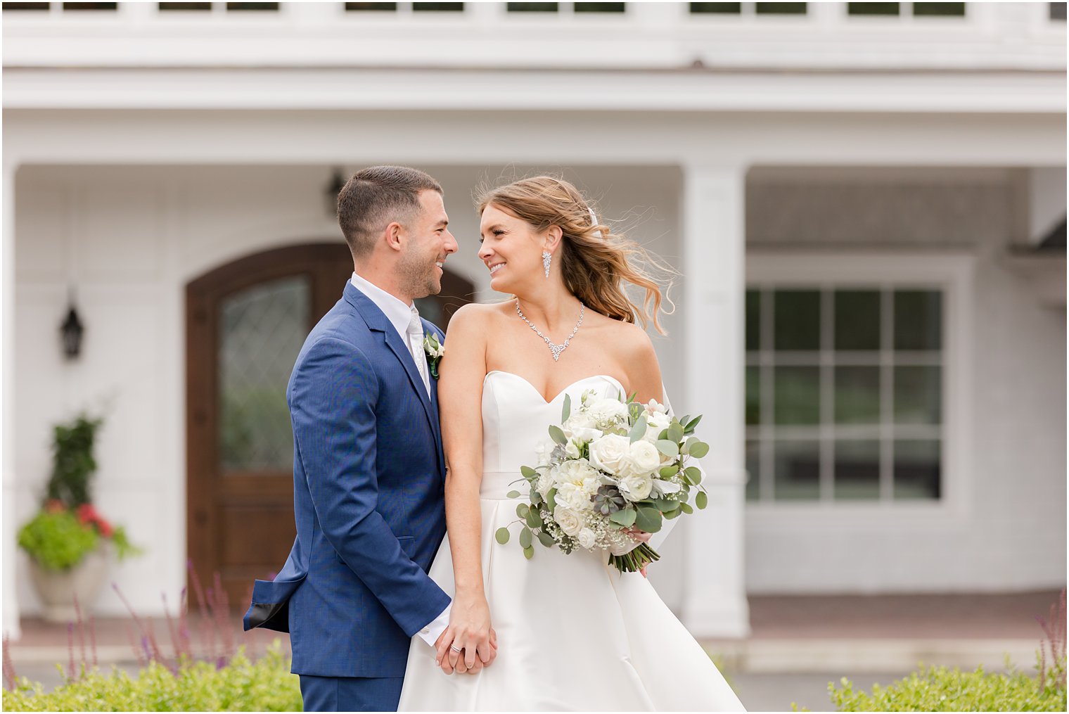 bride and groom hold hands standing outside The Mill Lakeside Manor