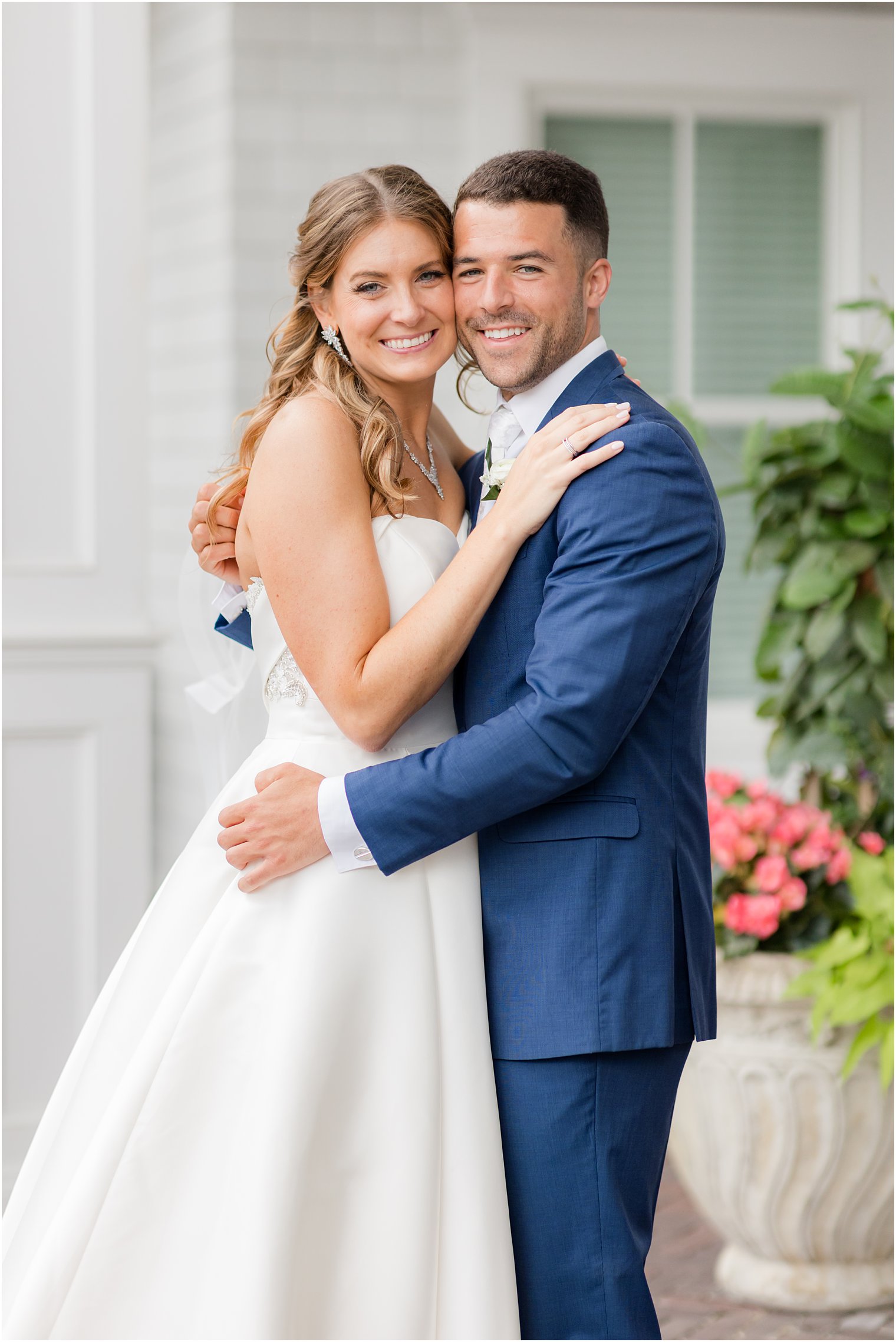 newlyweds hug on porch of The Mill Lakeside Manor