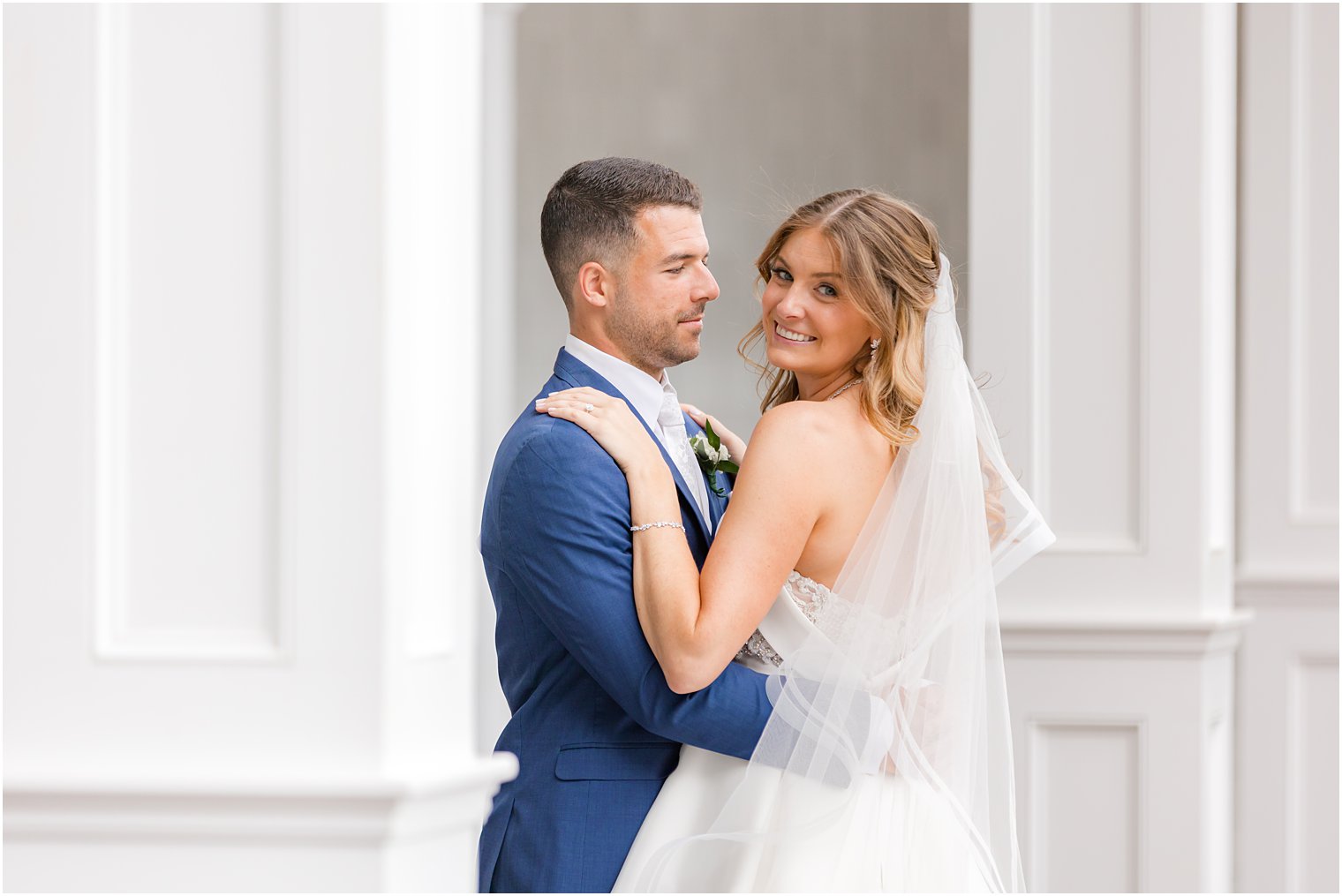 groom hugs bride while she looks over shoulder at The Mill Lakeside Manor