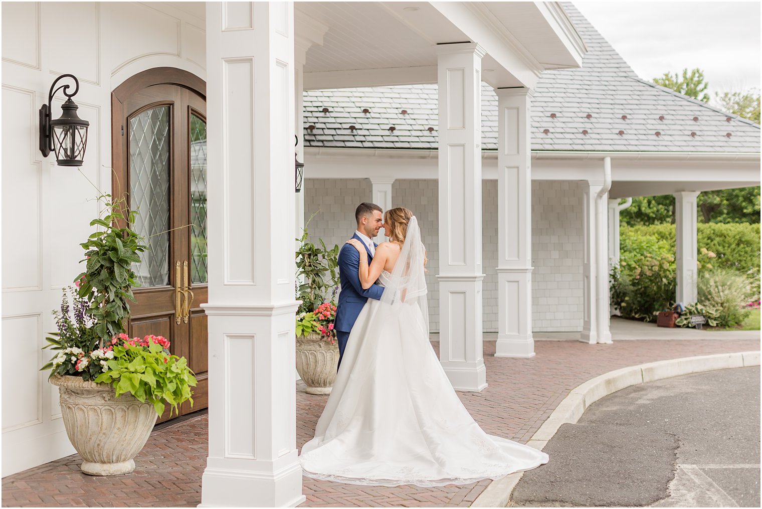 bride and groom stand on walkway outside The Mill Lakeside Manor
