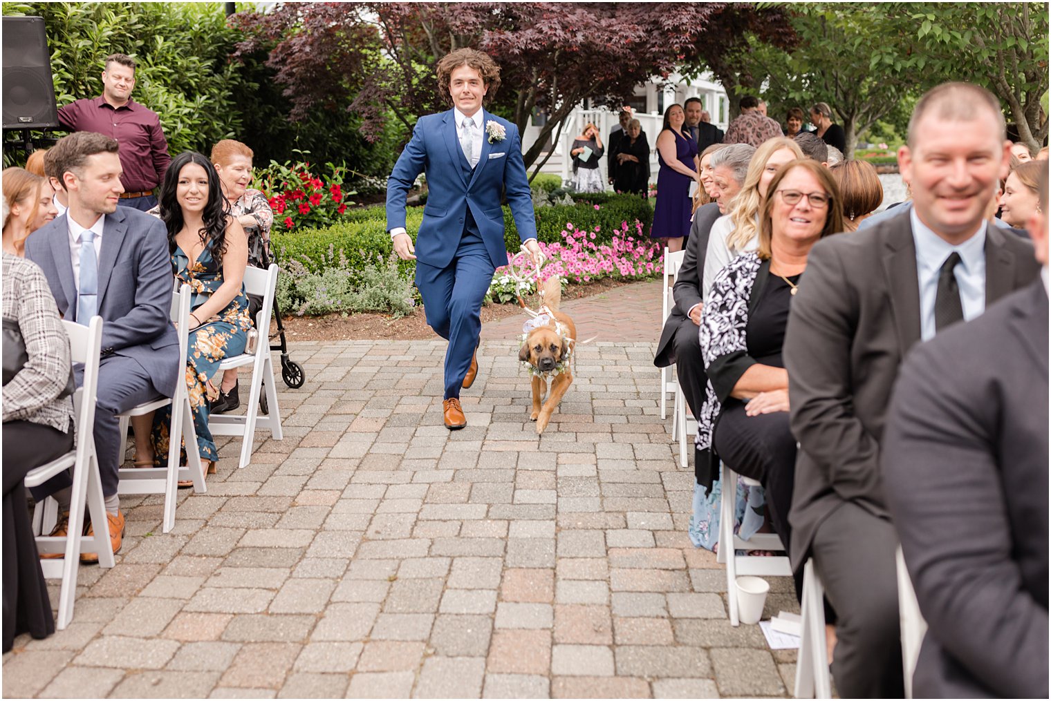 groomsman walks dog down aisle for Spring Lake NJ wedding ceremony