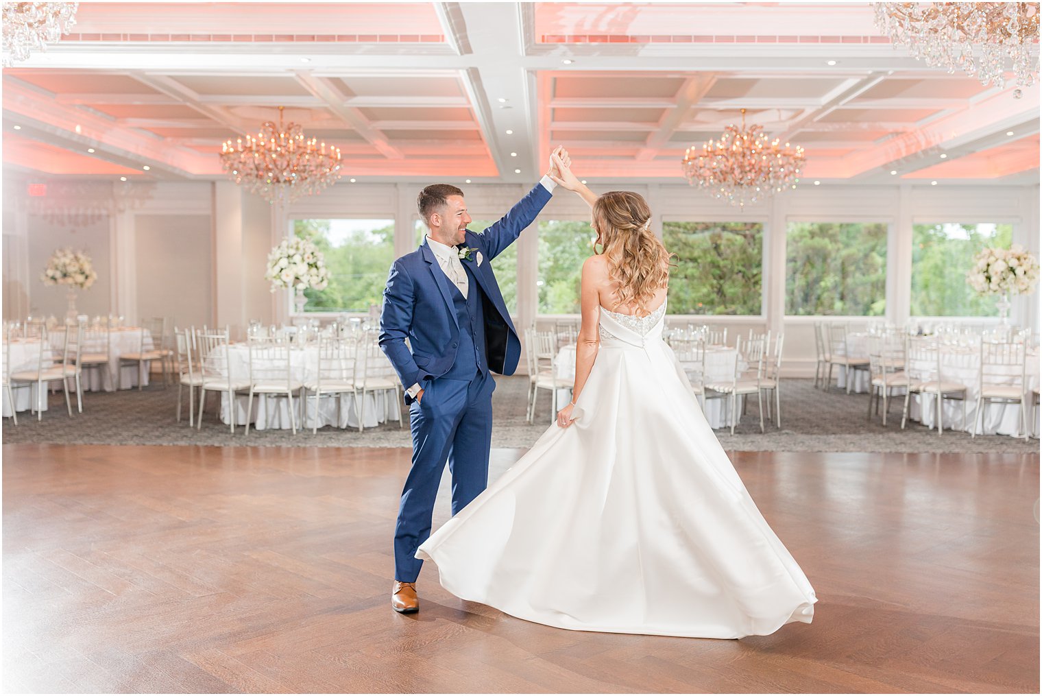 groom twirls bride in ballroom of The Mill Lakeside Manor