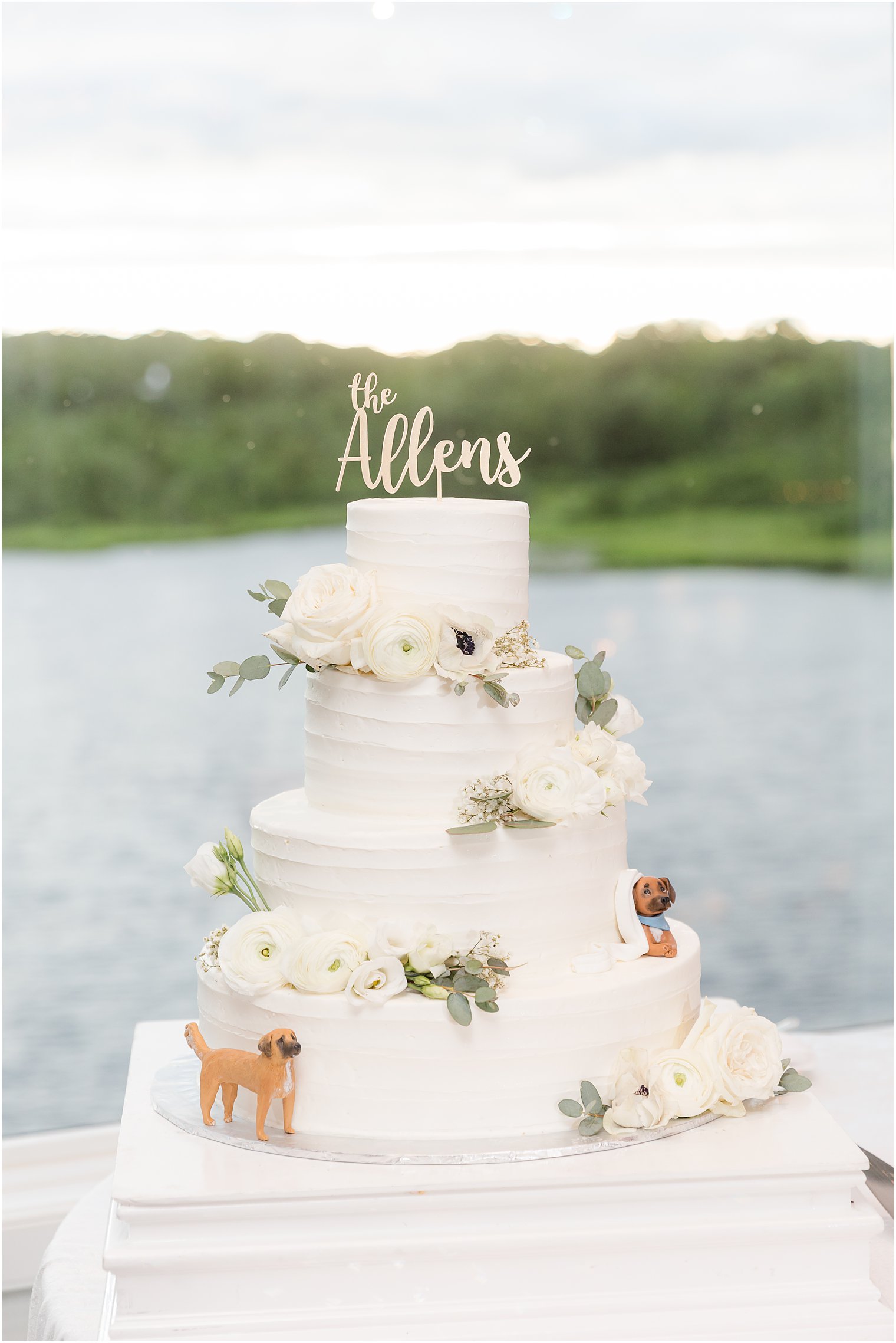 tiered wedding cake with custom topper and floral accents