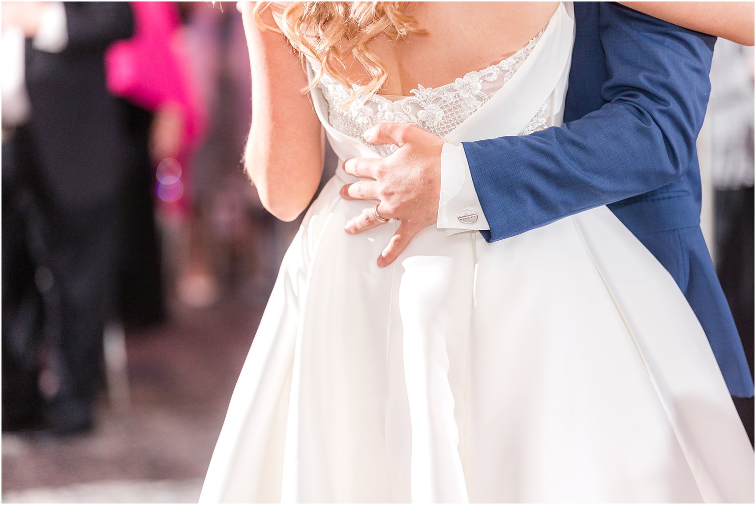 groom holds bride's back during first dance 