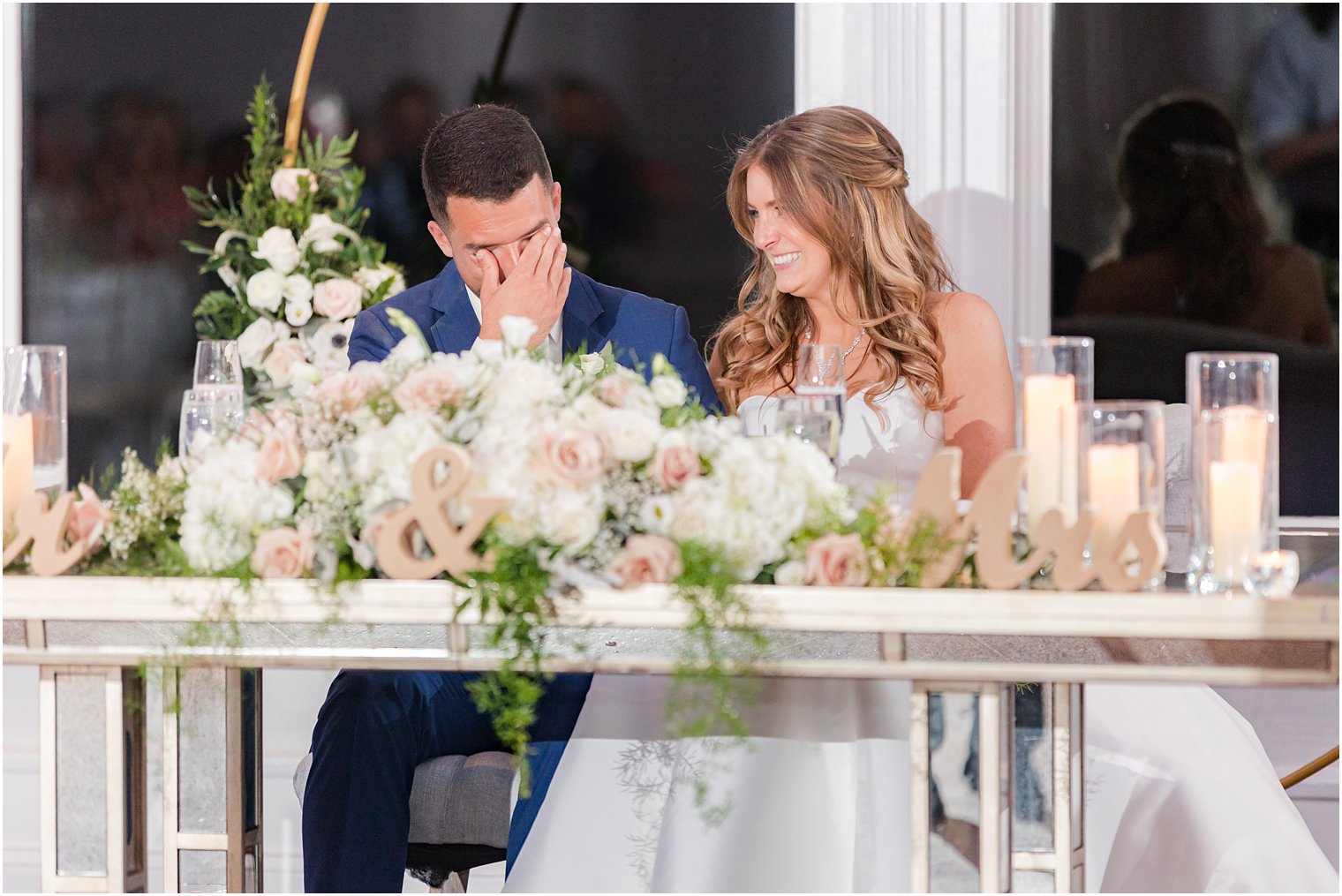 bride and groom laugh sitting at sweetheart table during Spring Lake NJ wedding reception