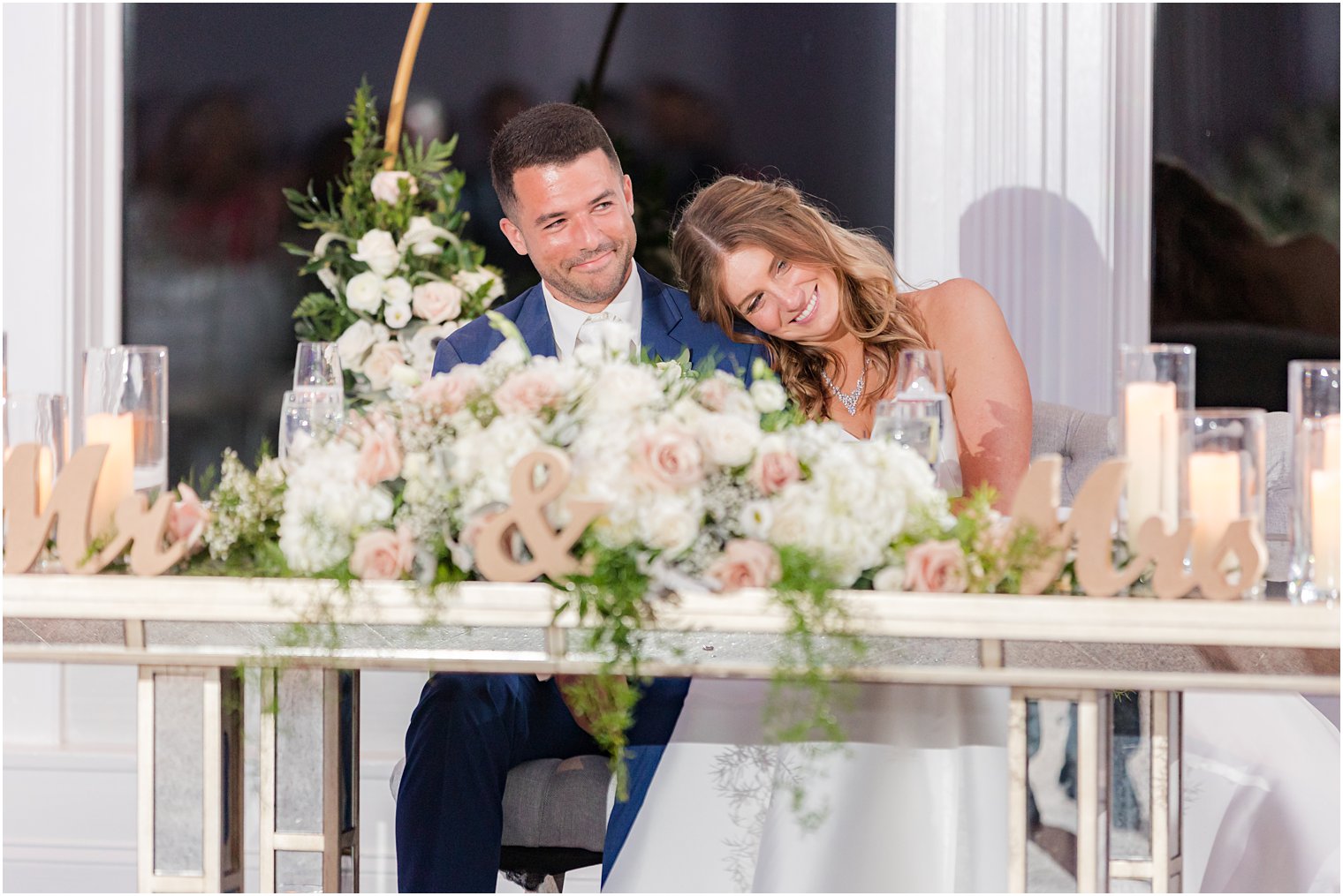 bride and groom laugh sitting at sweetheart table during Spring Lake NJ wedding reception