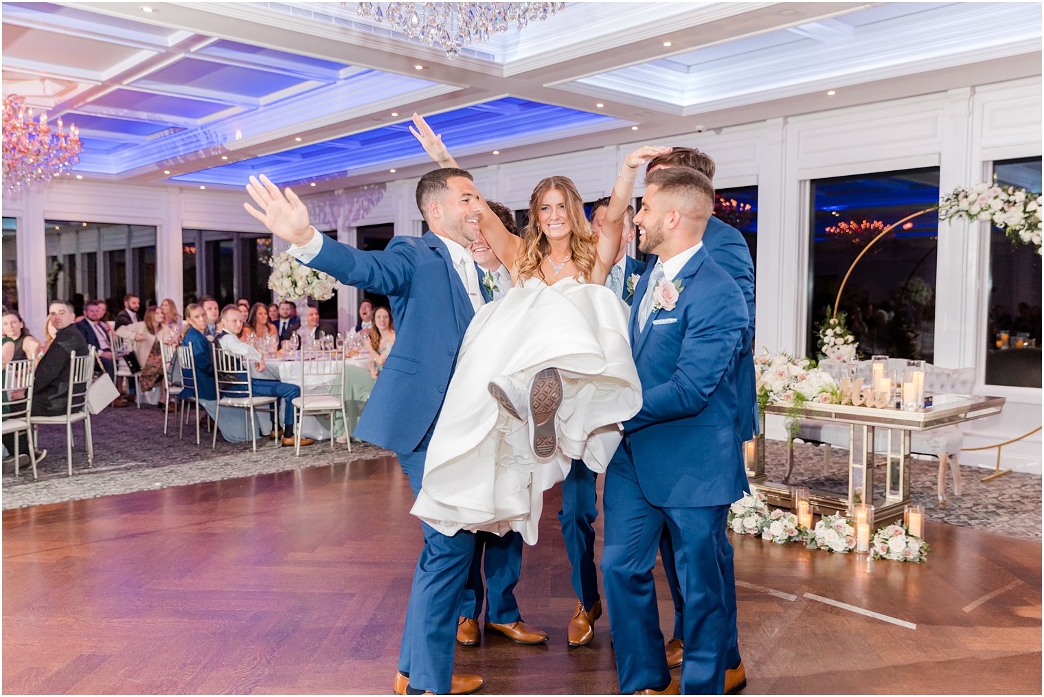groomsmen lift up bride on dance floor