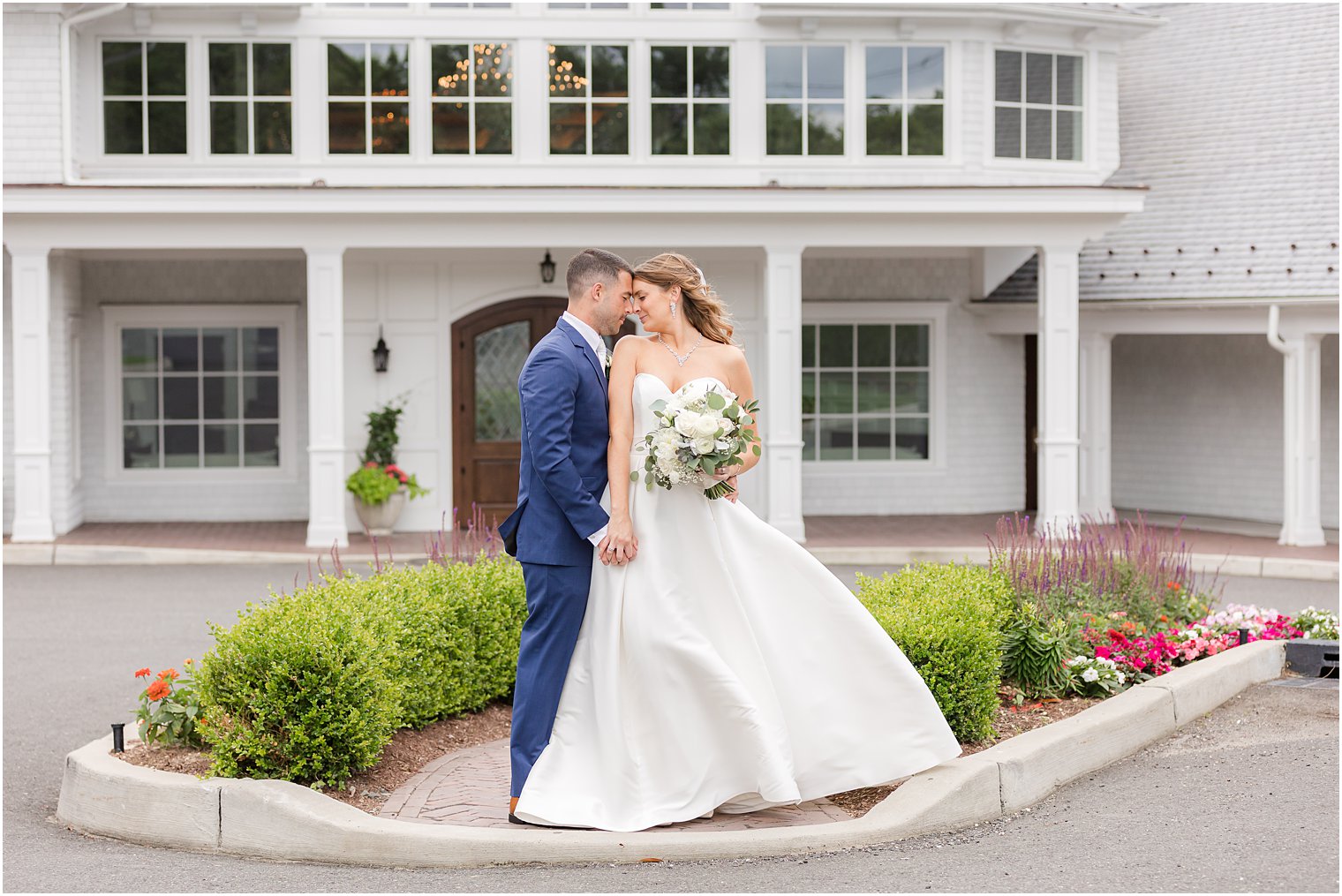 newlyweds stand with bride's back to groom's front outside The Mill Lakeside Manor