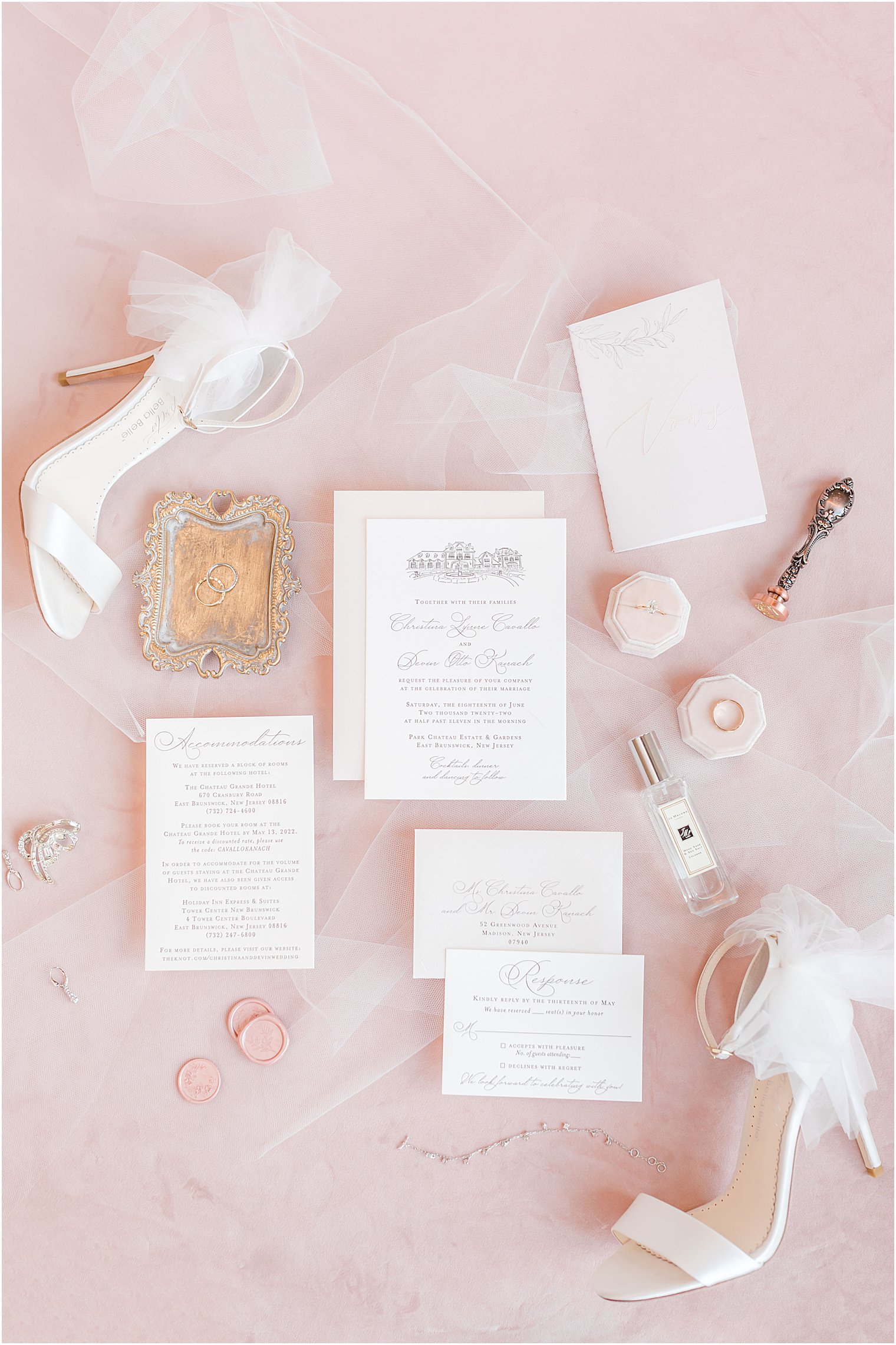 ivory invitation suite on pink backdrop with veil