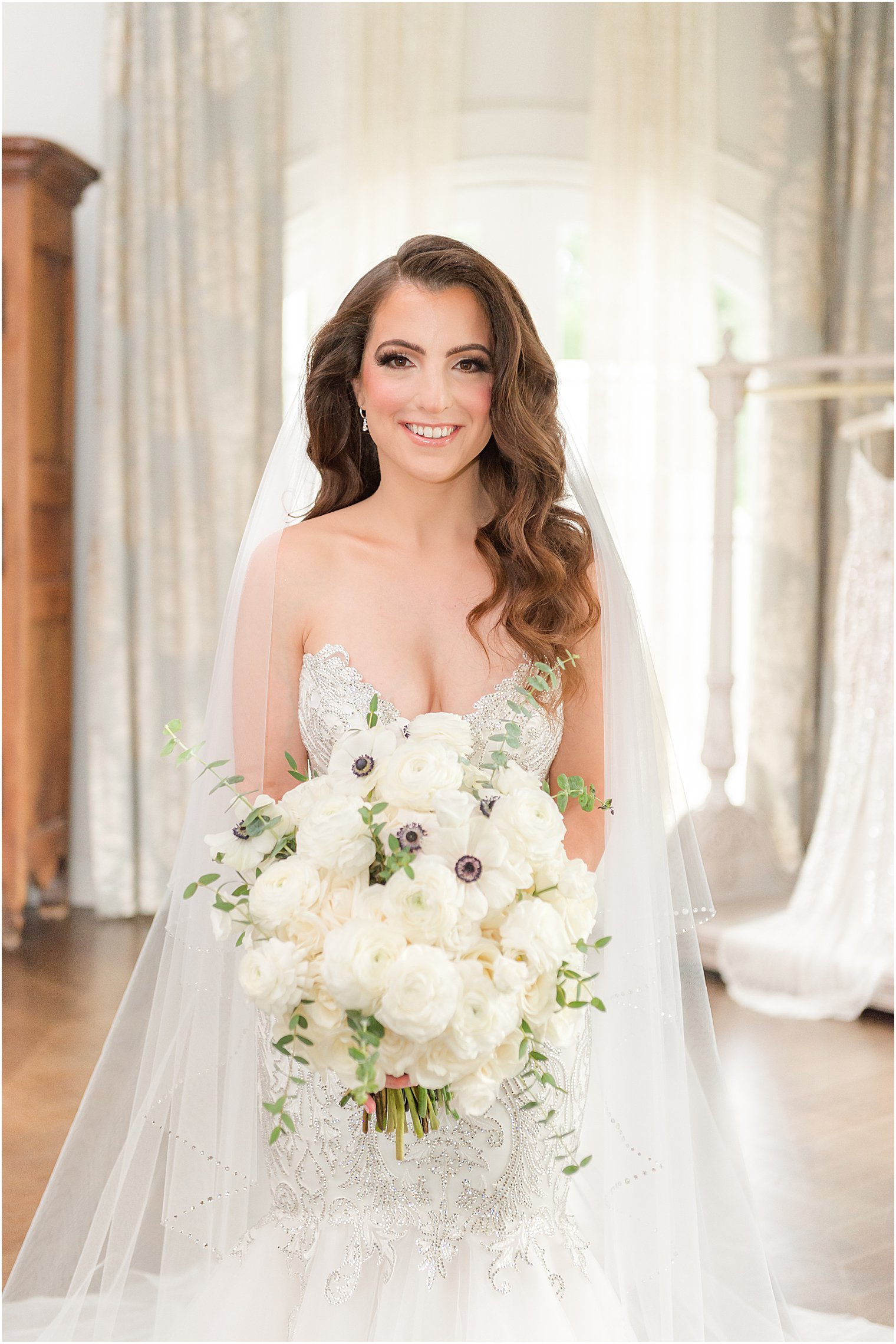 bride poses holding white bouquet for summer wedding