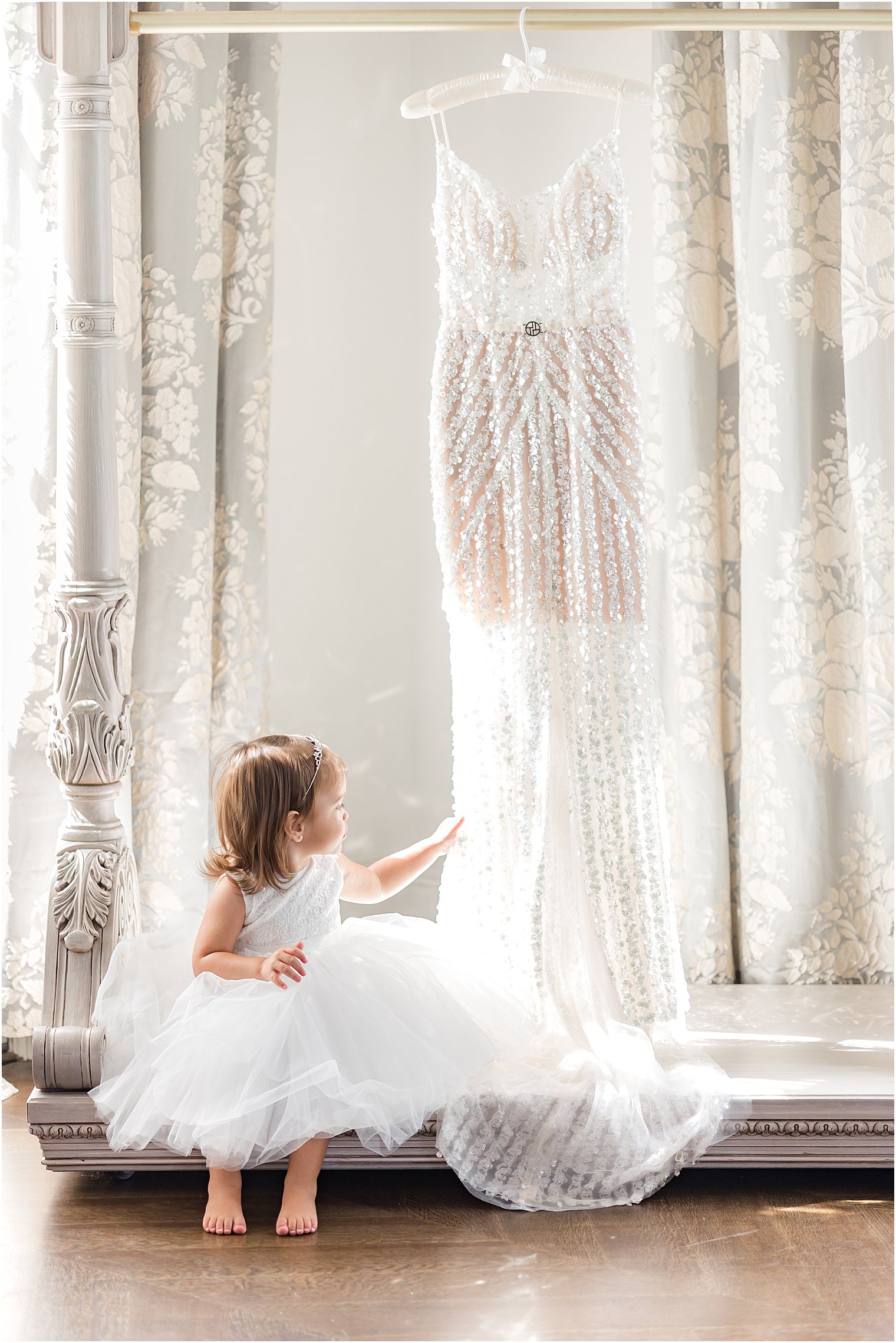 little girl looks at wedding dress hanging in bridal suite at Park Chateau Estate