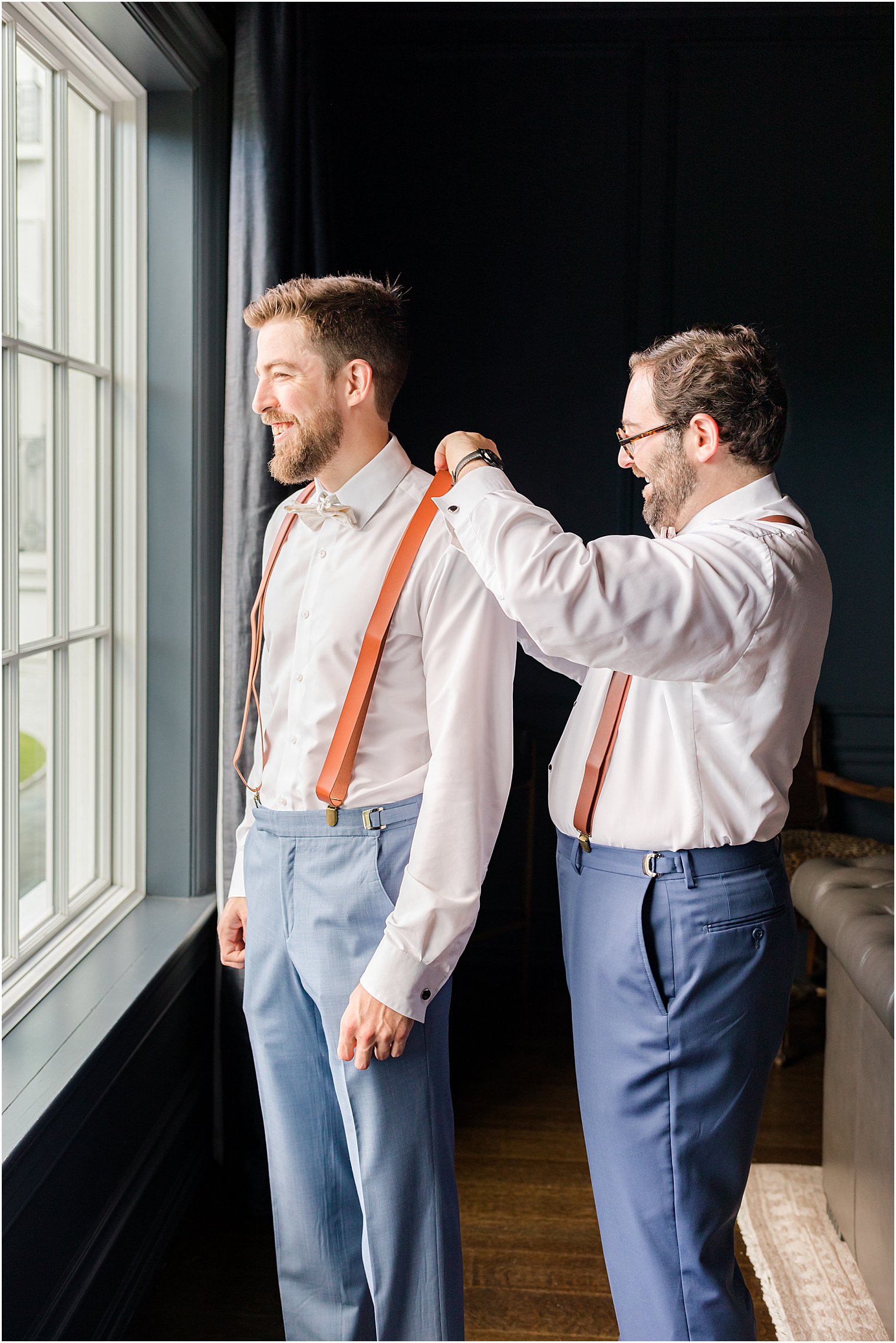 groomsman helps groom into jacket before NJ wedding