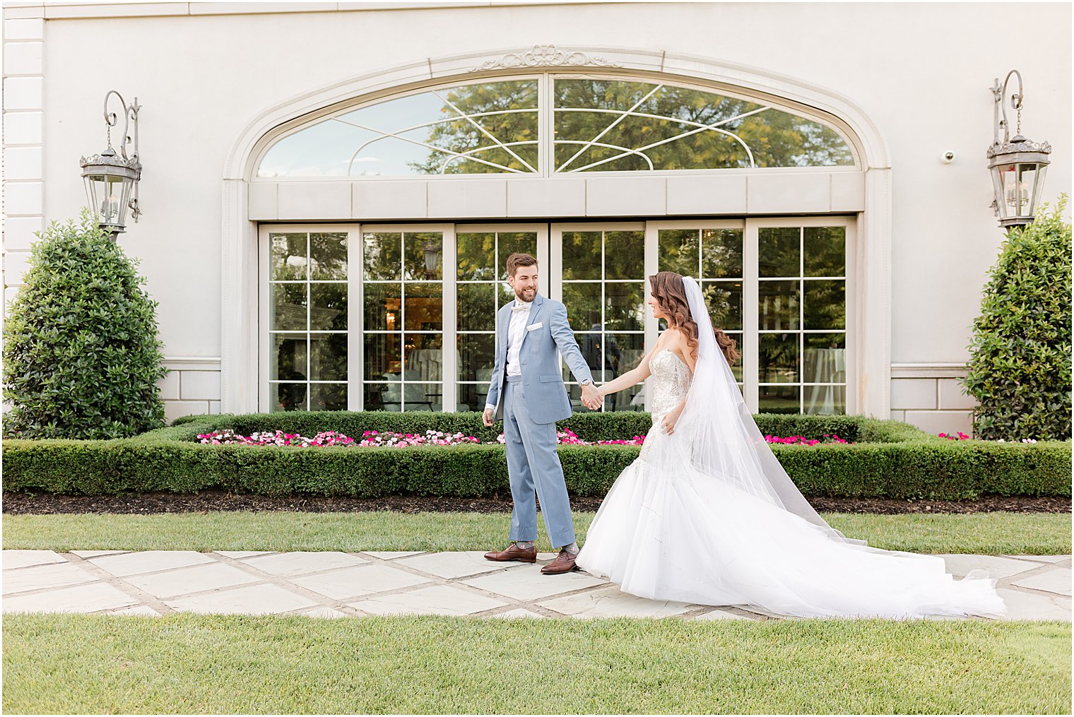 bride and groom hold hands walking across lawn at Park Chateau Estate