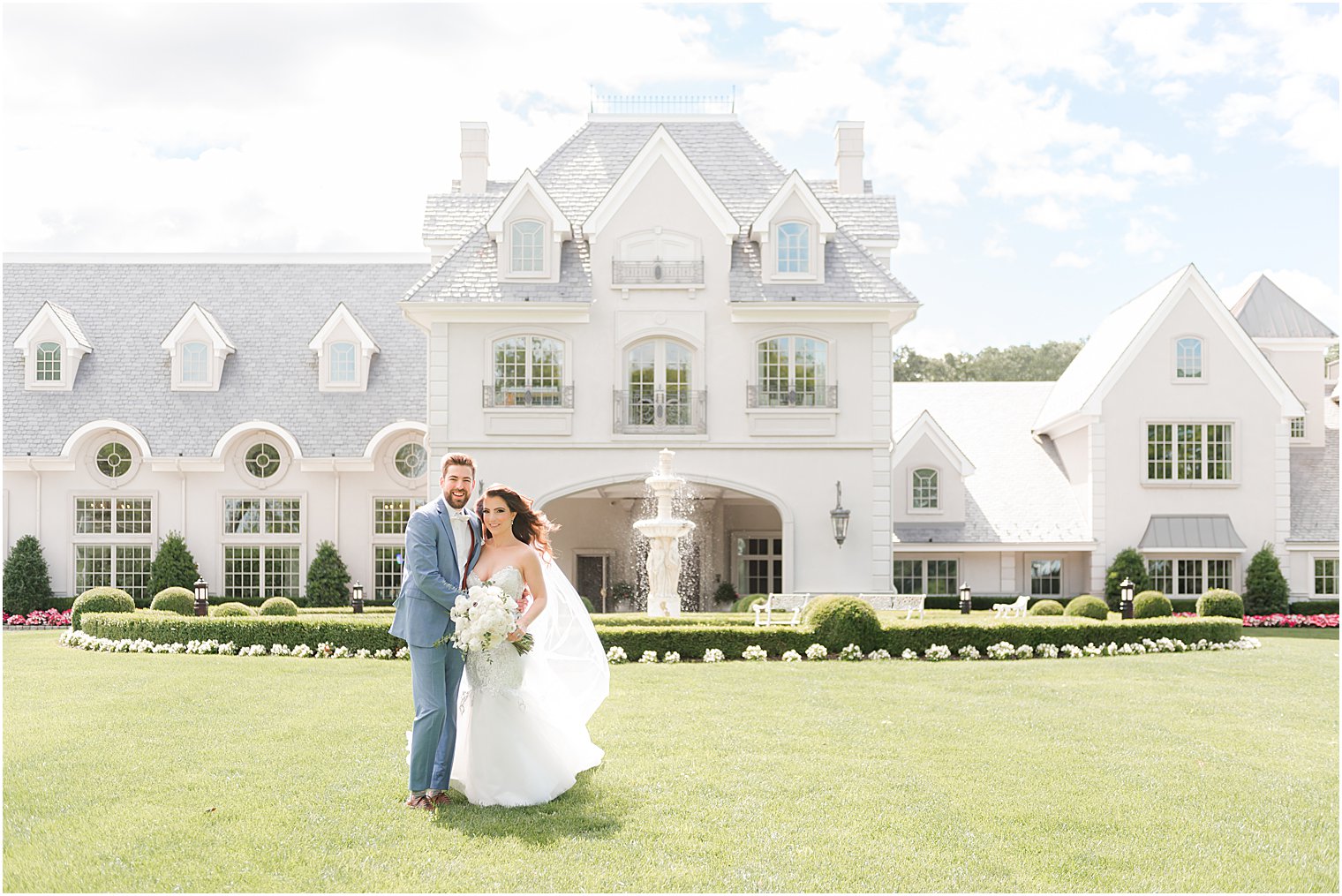 bride and groom stand on front lawn of Park Chateau Estate