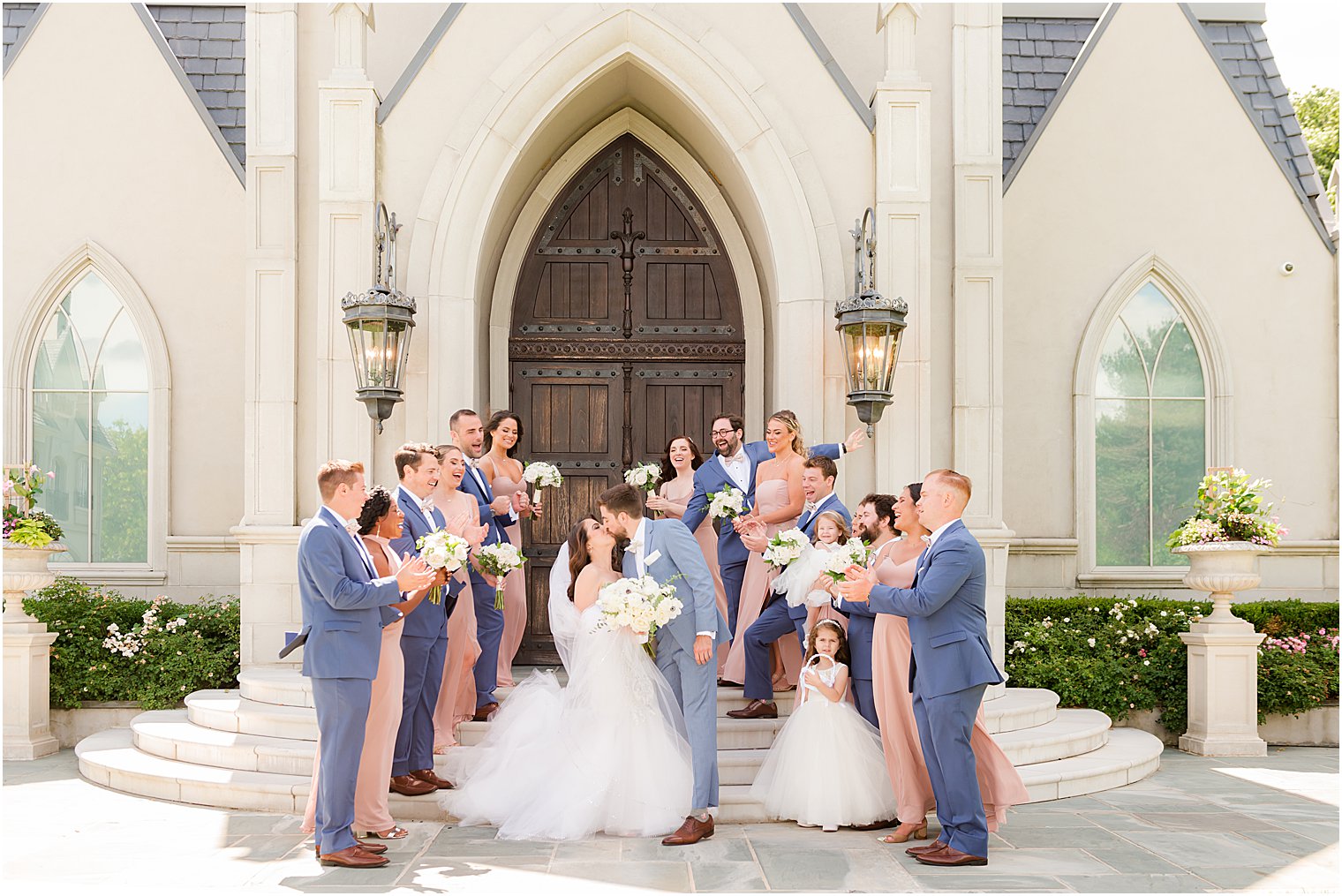 bride and groom stand on steps of chapel at Park Chateau Estate with wedding party