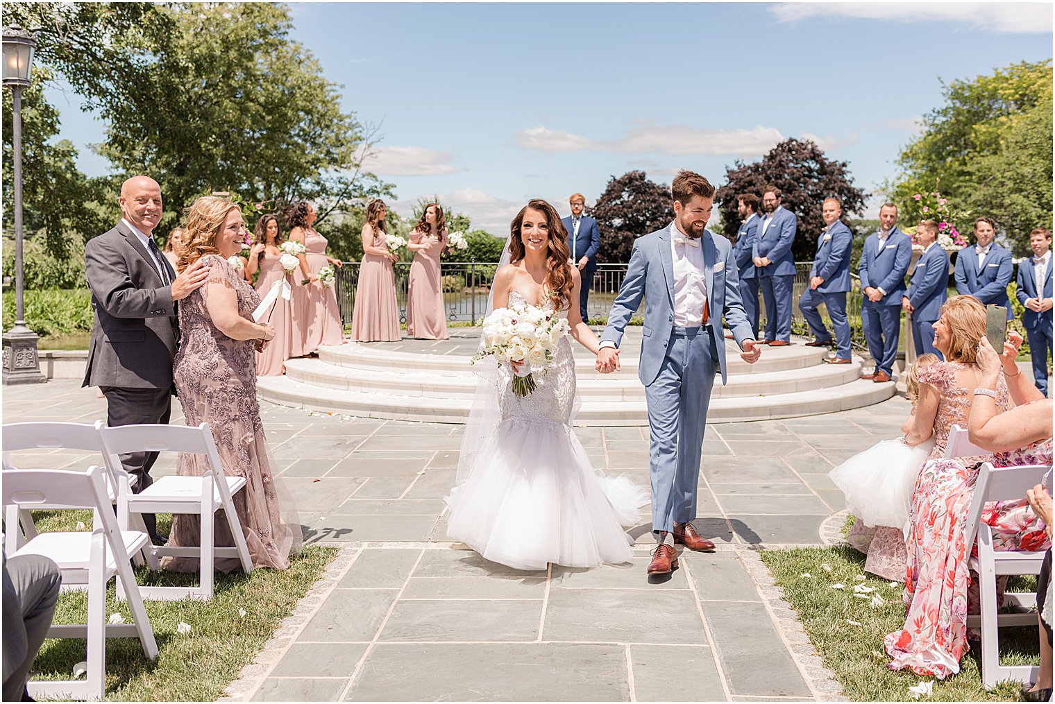 bride and groom hold ands walking up aisle after ceremony at Park Chateau Estate