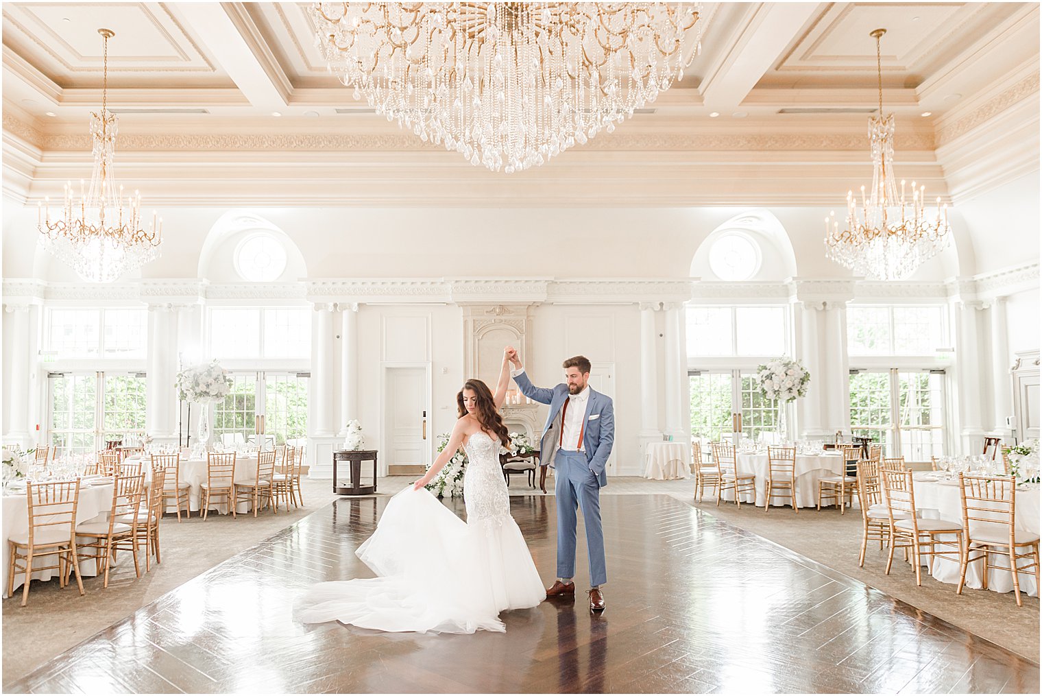 groom twirls bride in empty ballroom at Park Chateau Estate