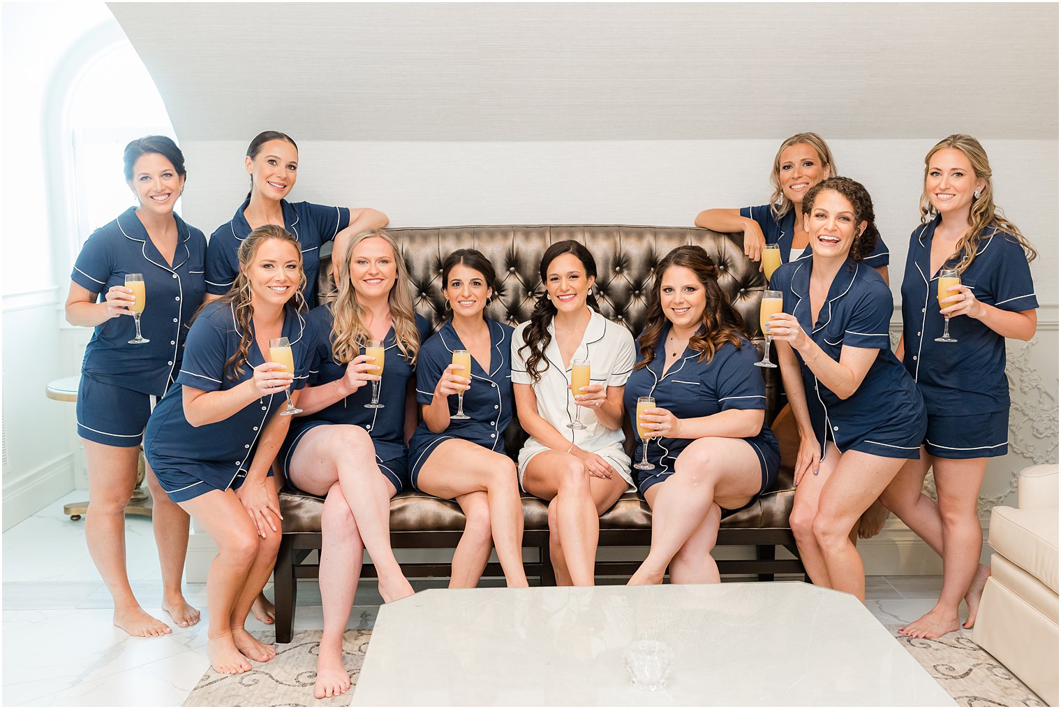 bride sits with bridesmaids in navy pajamas at Shadowbrook at Shrewsbury