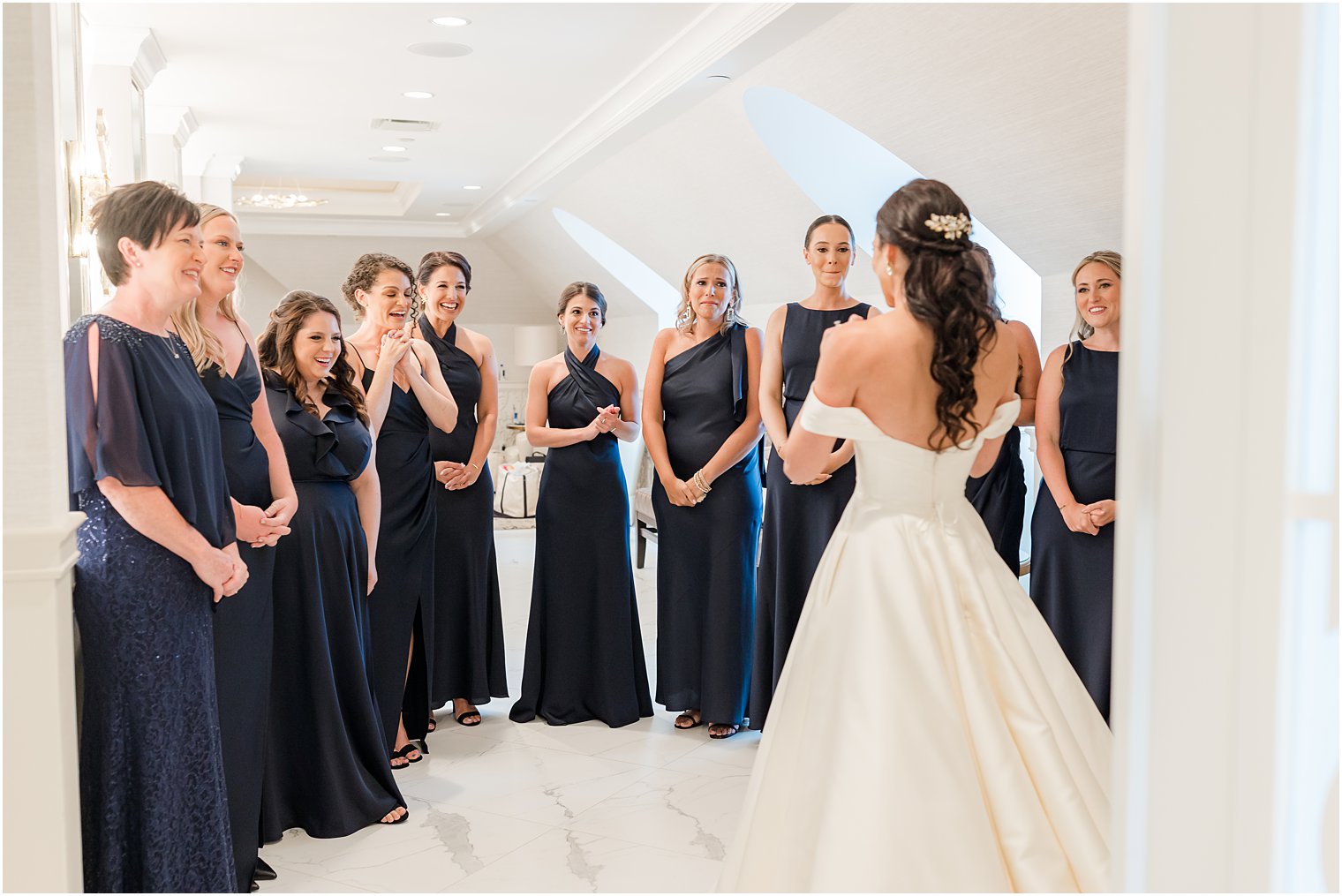 bride has first look with bridesmaids in navy gowns