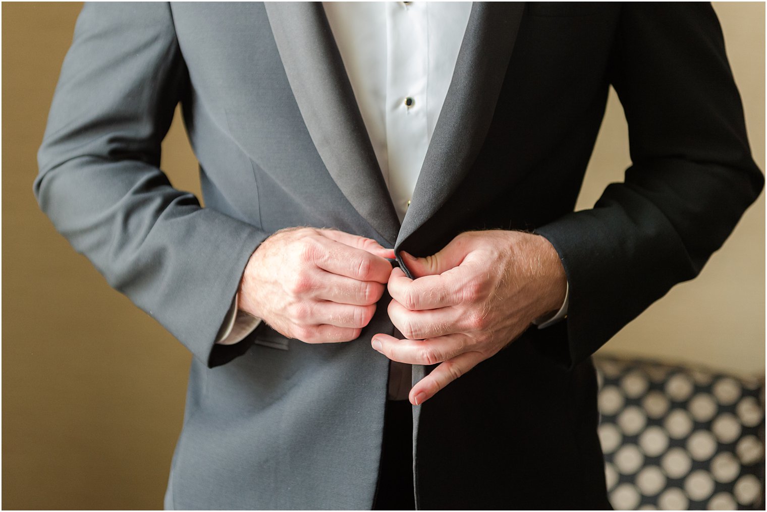groom adjusts jacket buttons