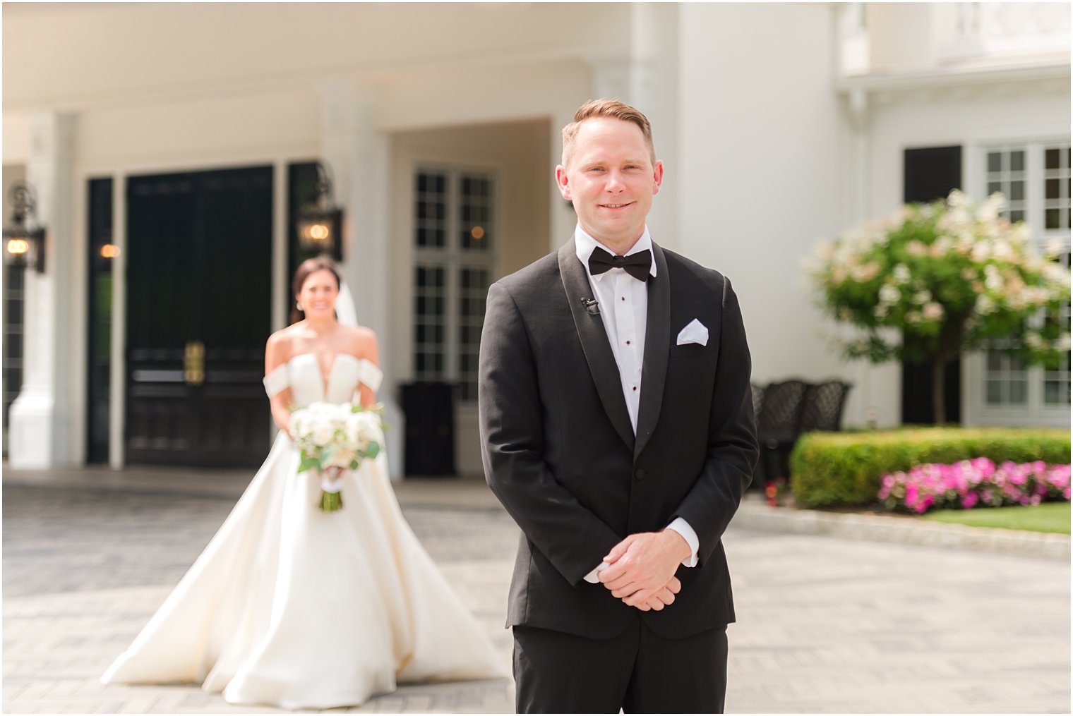 groom waits for bride during first look at Shadowbrook at Shrewsbury