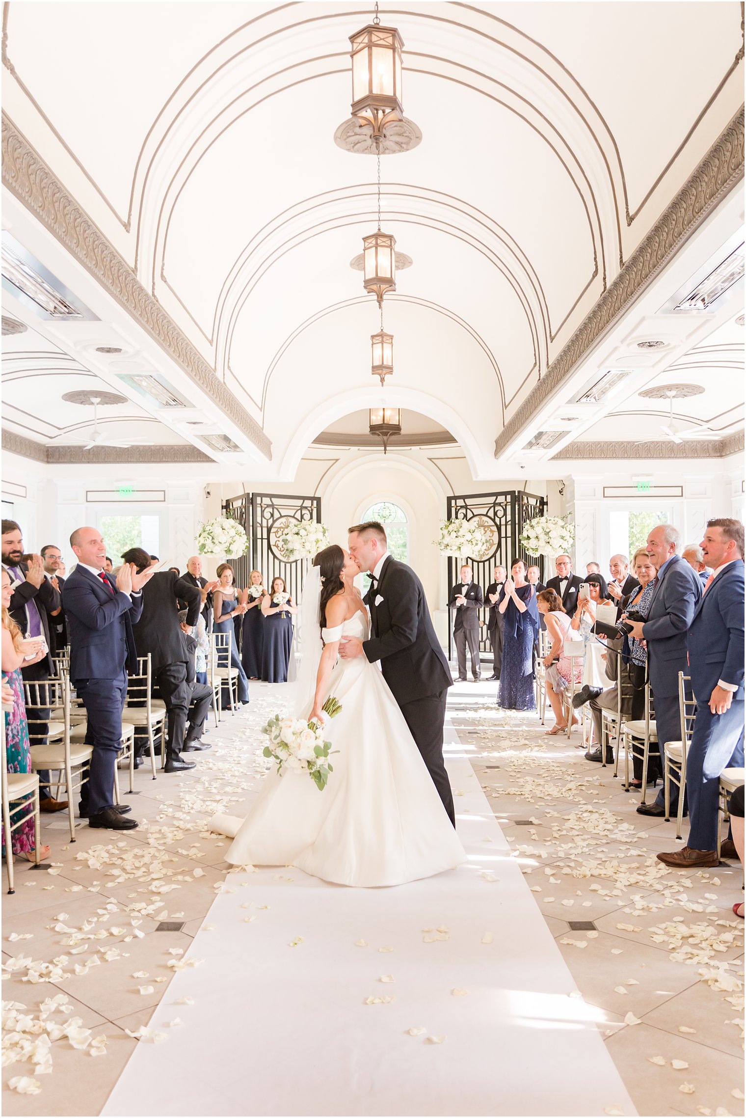 newlyweds kiss walking down aisle at Shadowbrook at Shrewbsury