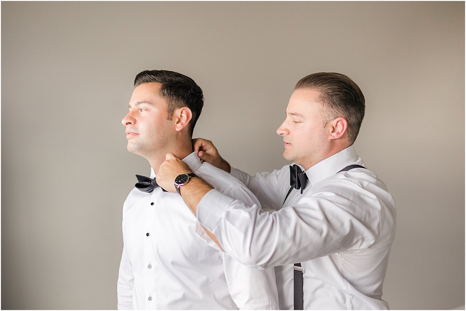 groomsman adjusts tie for groom