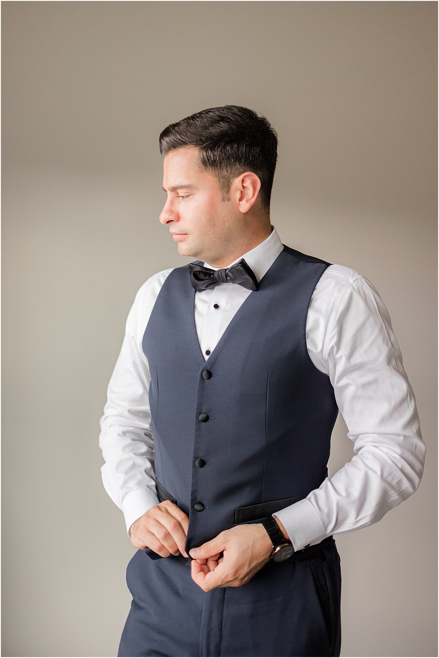 groom adjusts vest for NJ wedding day