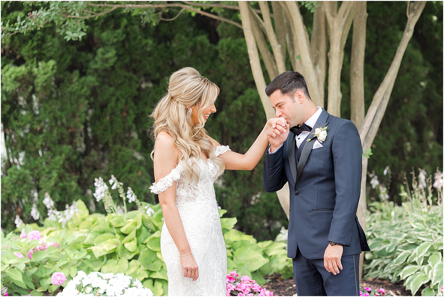 groom kisses bride's hand during first look at The English Manor