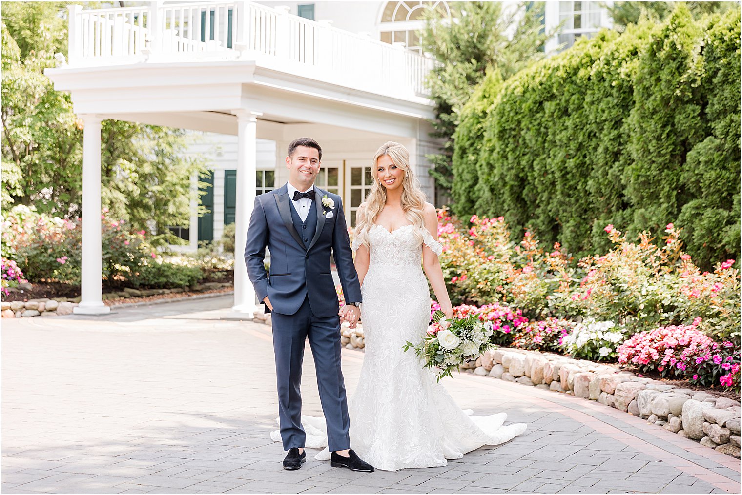 newlyweds hold hands and walk in driveway at The English Manor