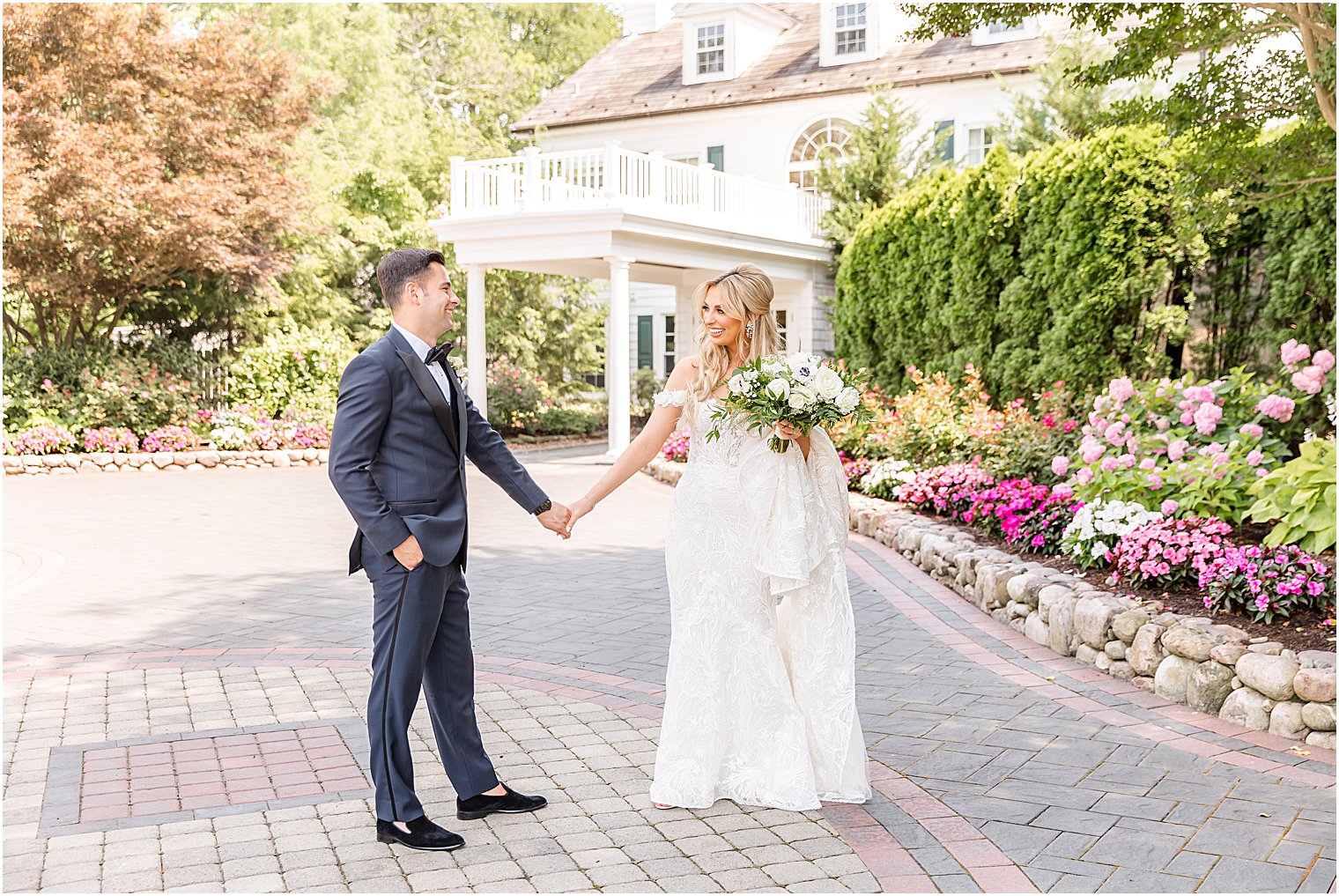 bride and groom hold hands standing on driveway at The English Manor