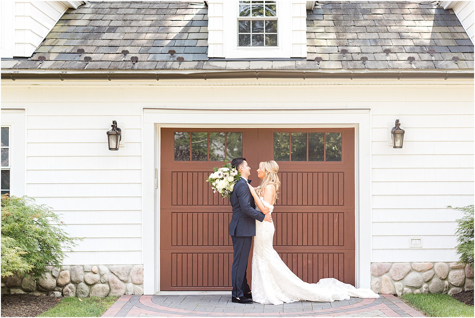 bride and groom kiss by brown door at The English Manor