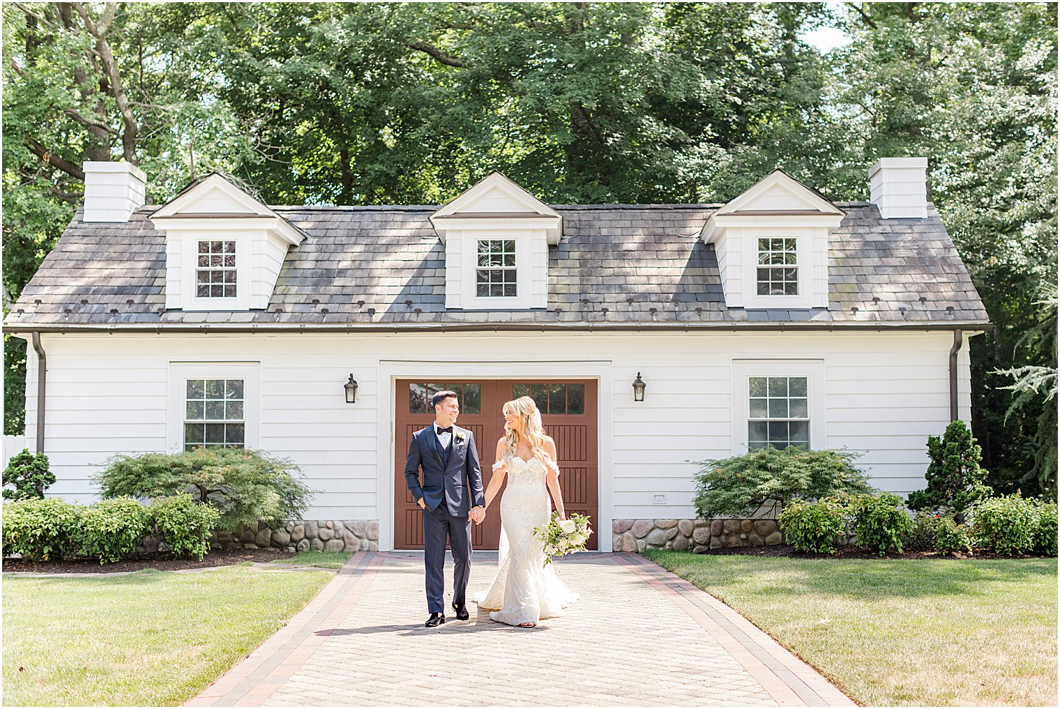 newlyweds walk with The English Manor brown door behind them