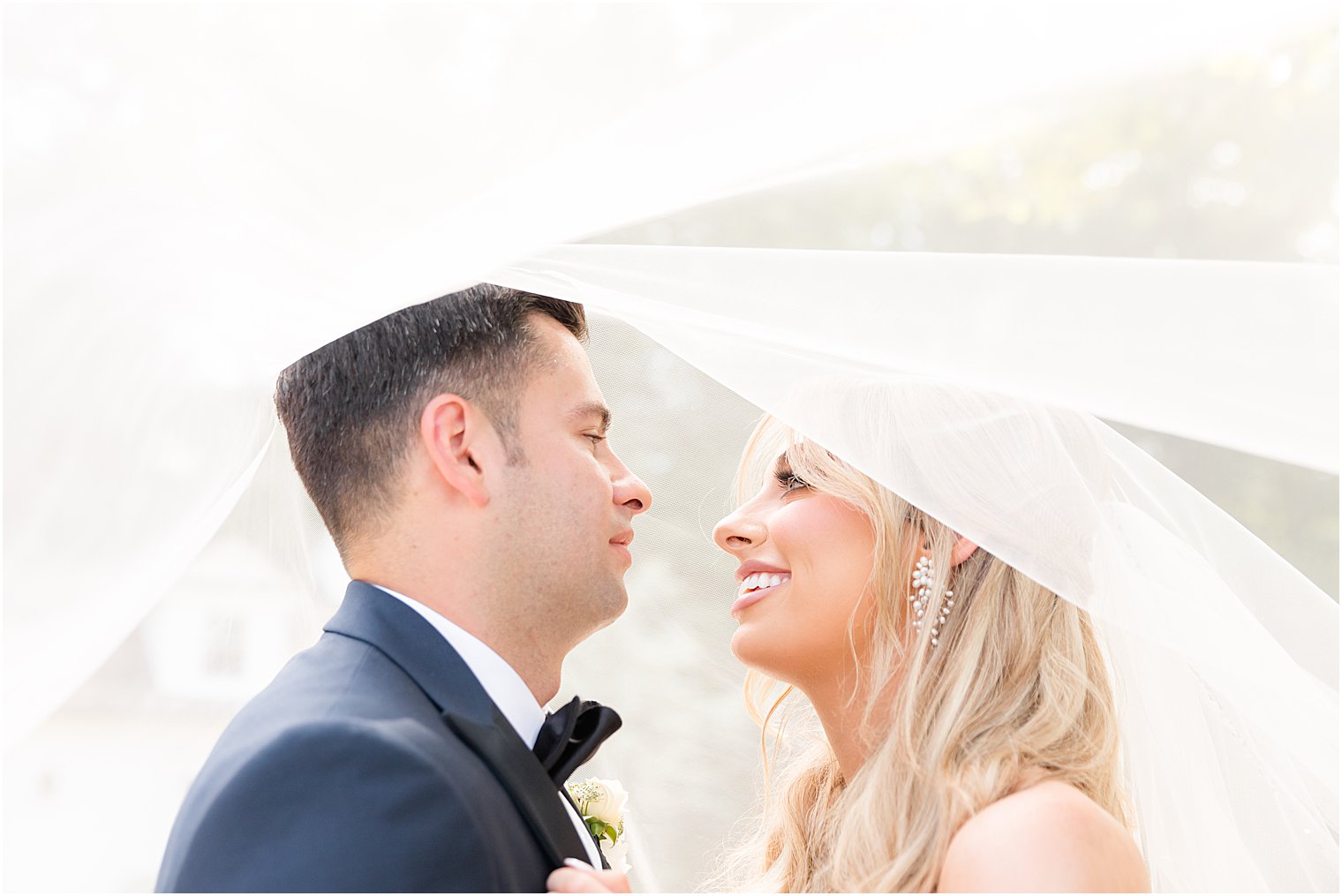 bride and groom smile under veil at The English Manor