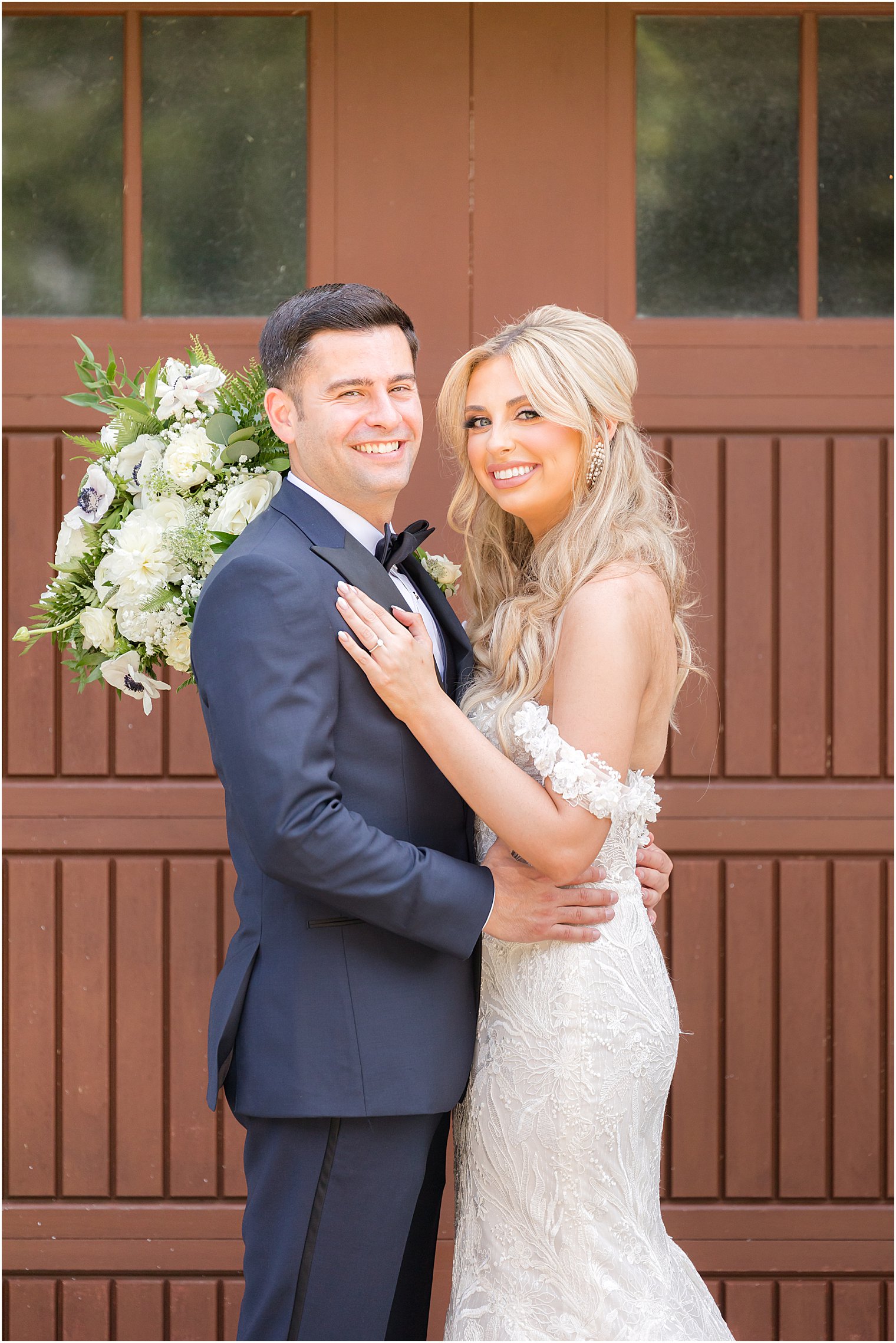 bride and groom pose outside brown door at The English Manor