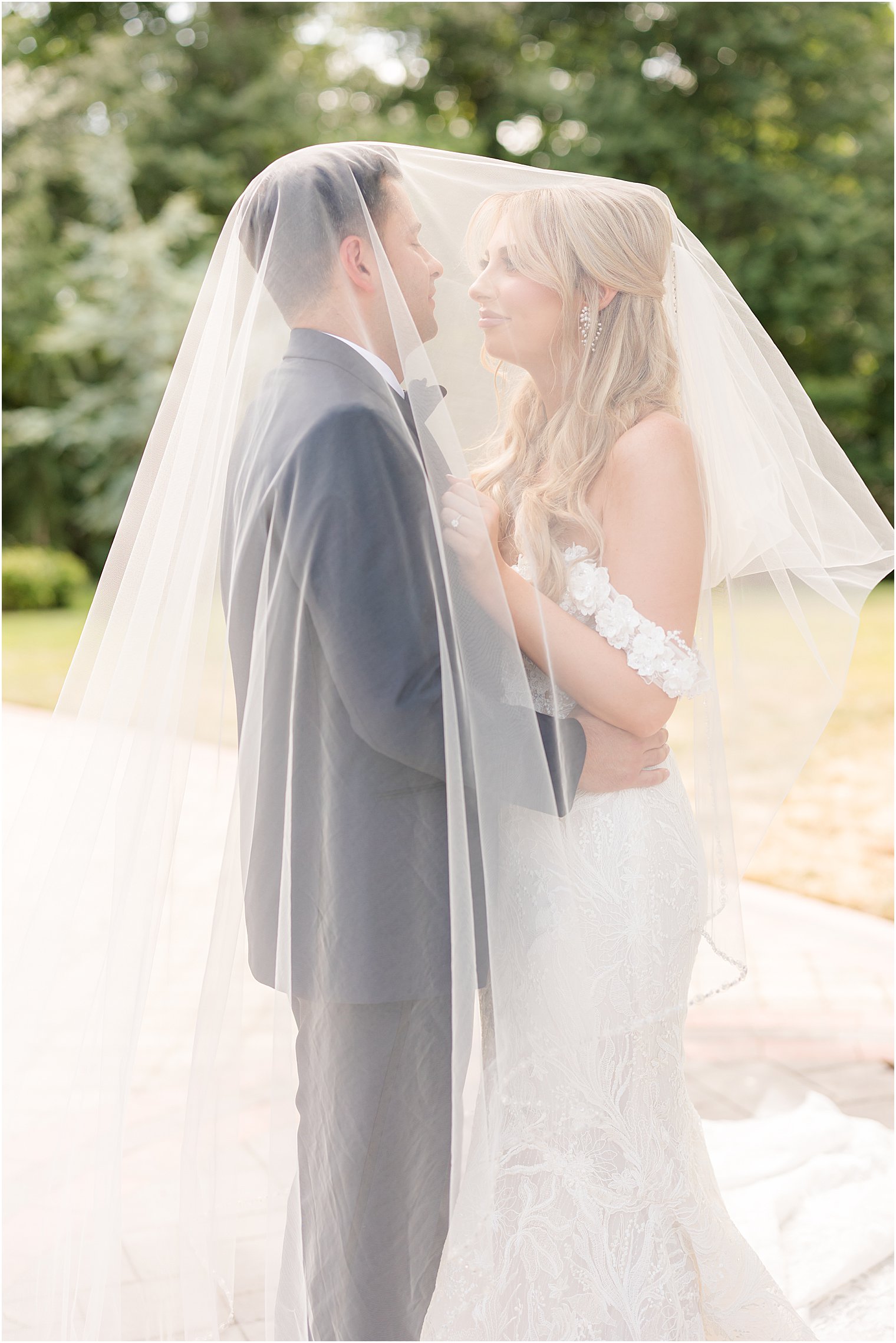 bride and groom hug under bride's veil at The English Manor