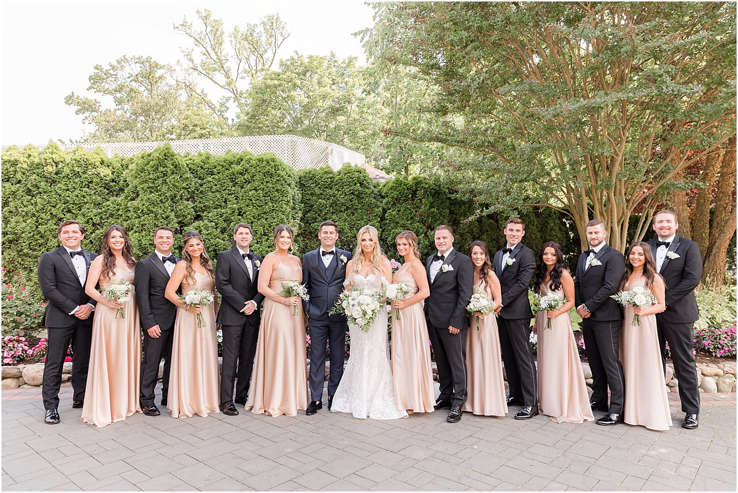 bride and groom pose with wedding party in champagne and black