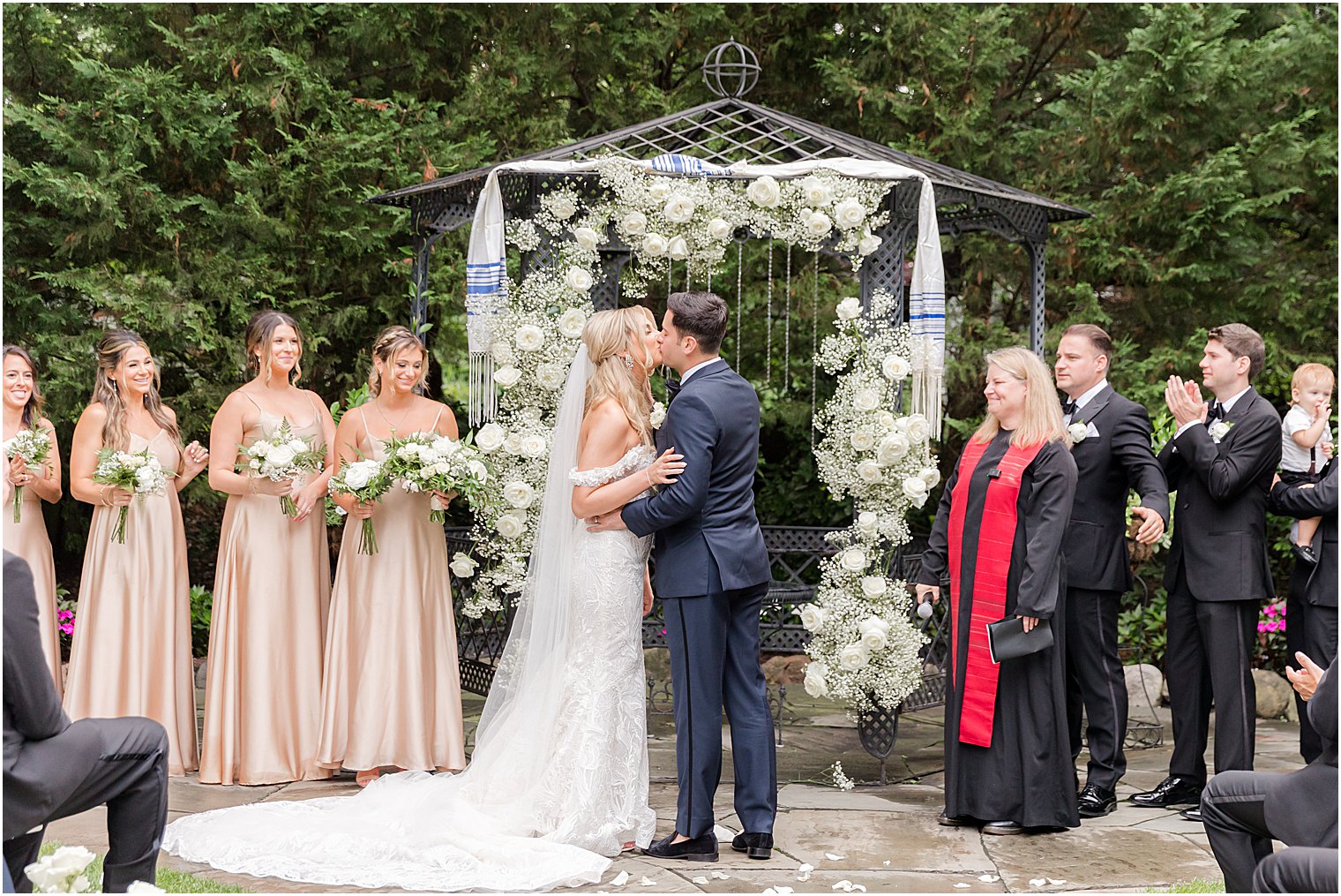 newlyweds kiss during Jewish ceremony in the gardens of The English Manor