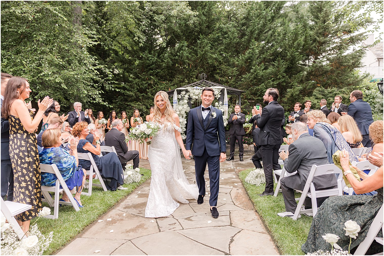 bride and groom walk up aisle after Jewish ceremony in the gardens of The English Manor