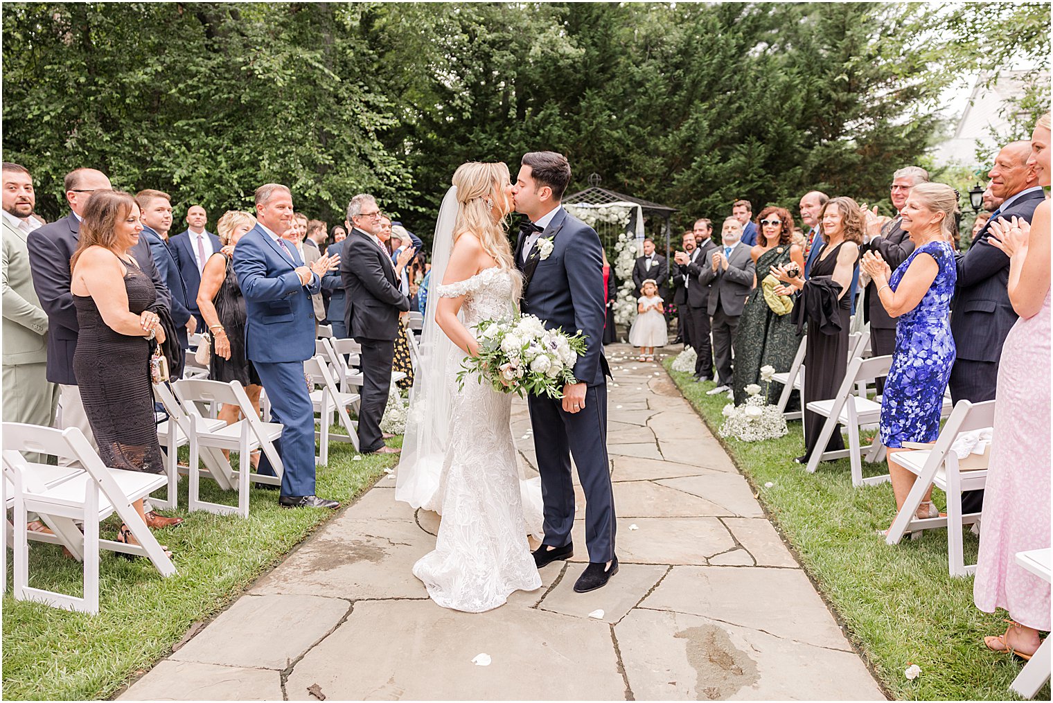 newlyweds kiss in aisle during Jewish ceremony in the gardens of The English Manor