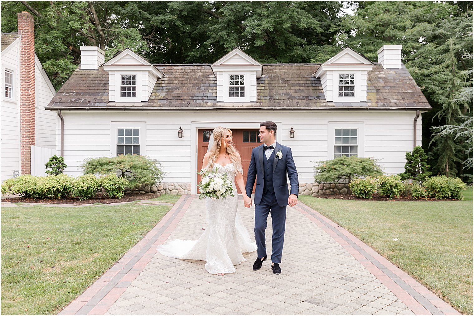 bride and groom walk outside house at The English Manor